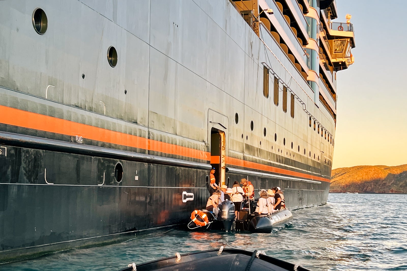 Passengers embark and disembark Zodiac boats from portways at the side of the ship.