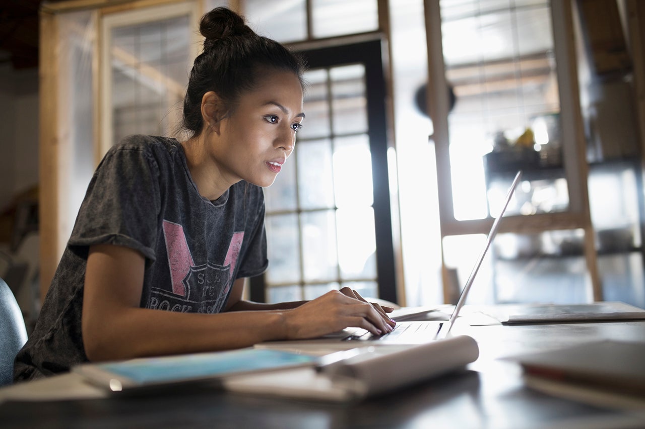 woman leaning forward looking into a laptop screen