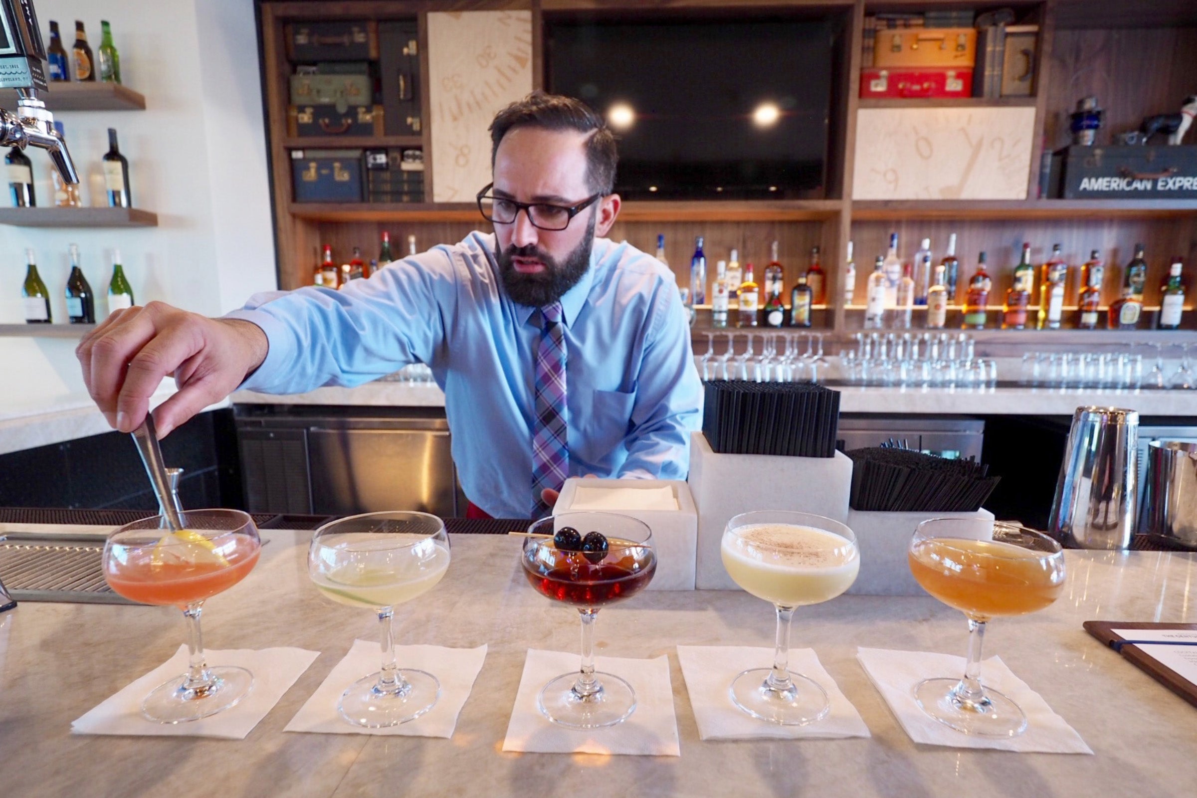 a bartender adds finishing touches to cocktails