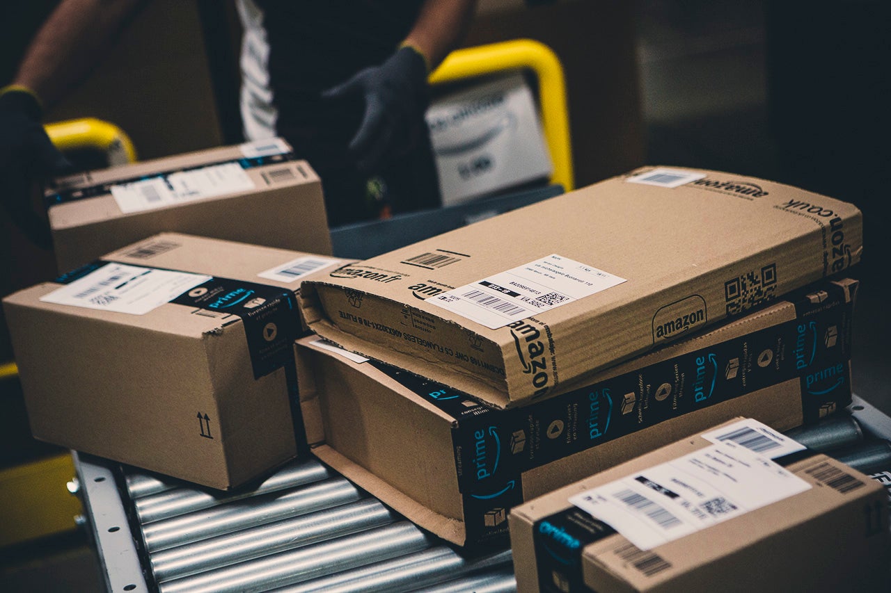 boxes with Amazon labeling move down a track to be loaded into a van