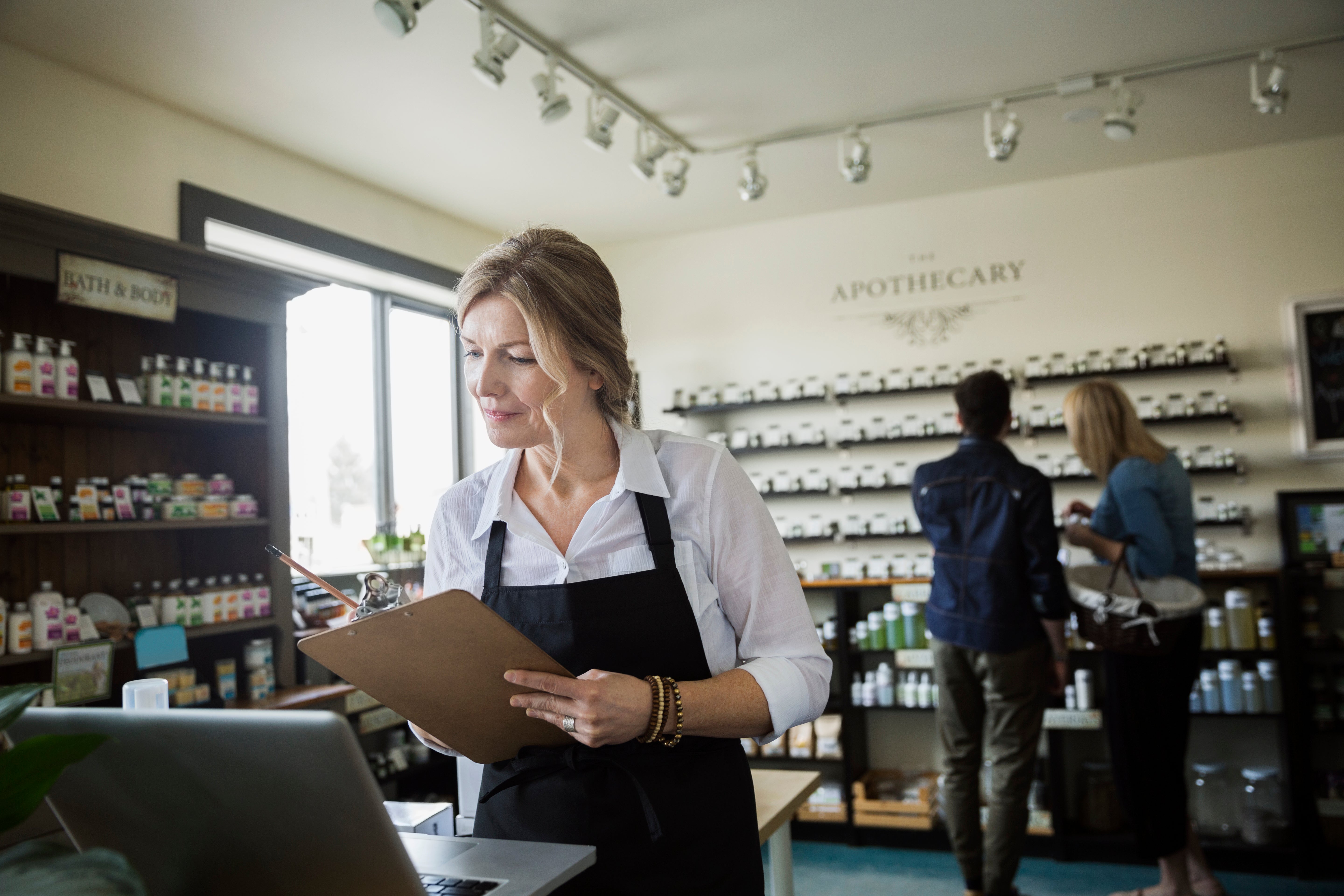 A shop owner checks her inventory on her computer.