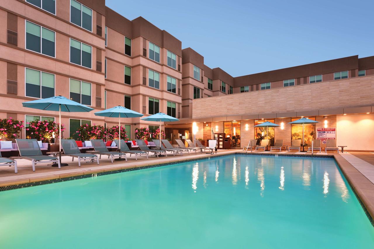 Empty loungers surround a pool in the evening