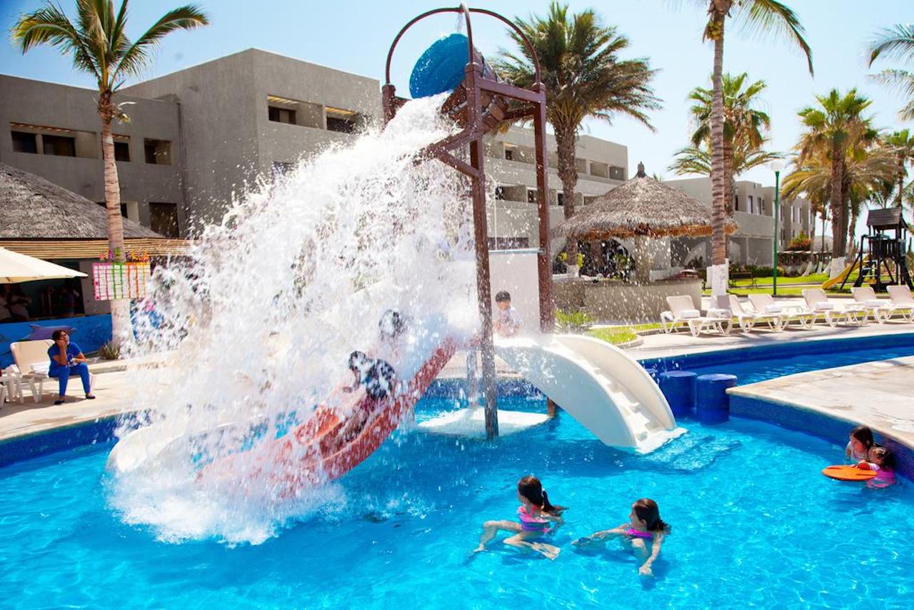 children play in a pool with slides and dump buckets