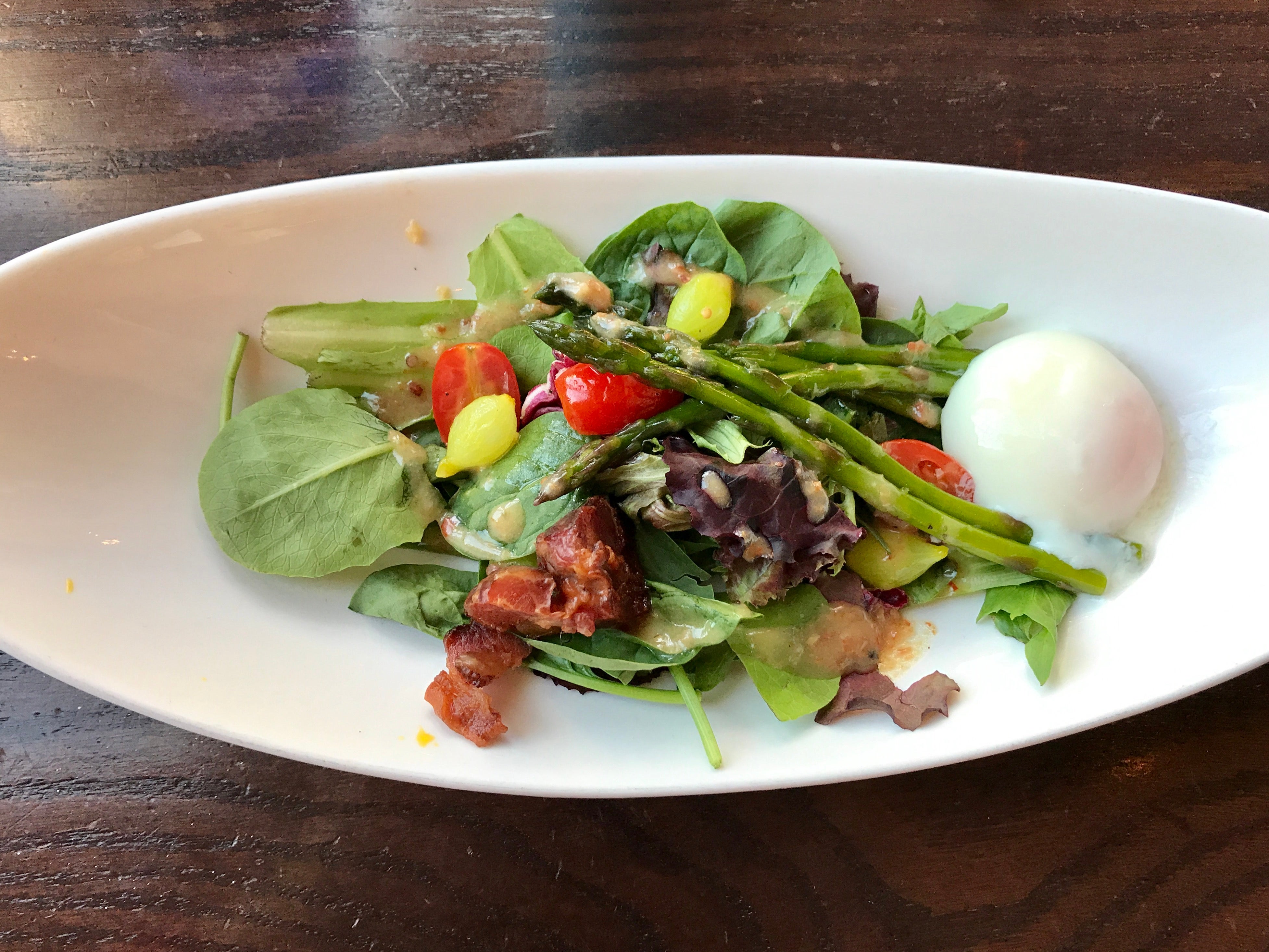 A salad with asparagus on a white plate at Cinderella's Royal Table in Disney World