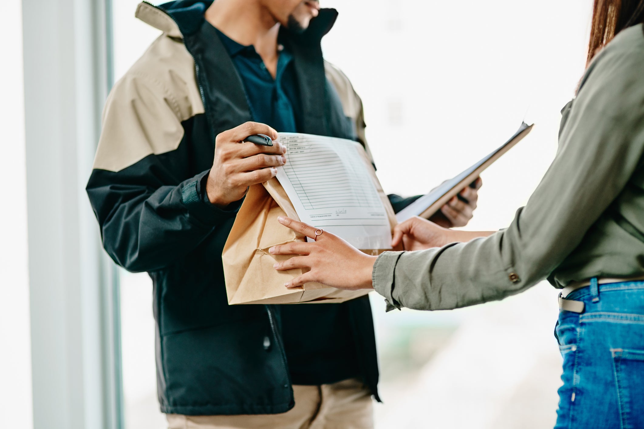 Food delivery worker hands over takeout food delivery bag to customer