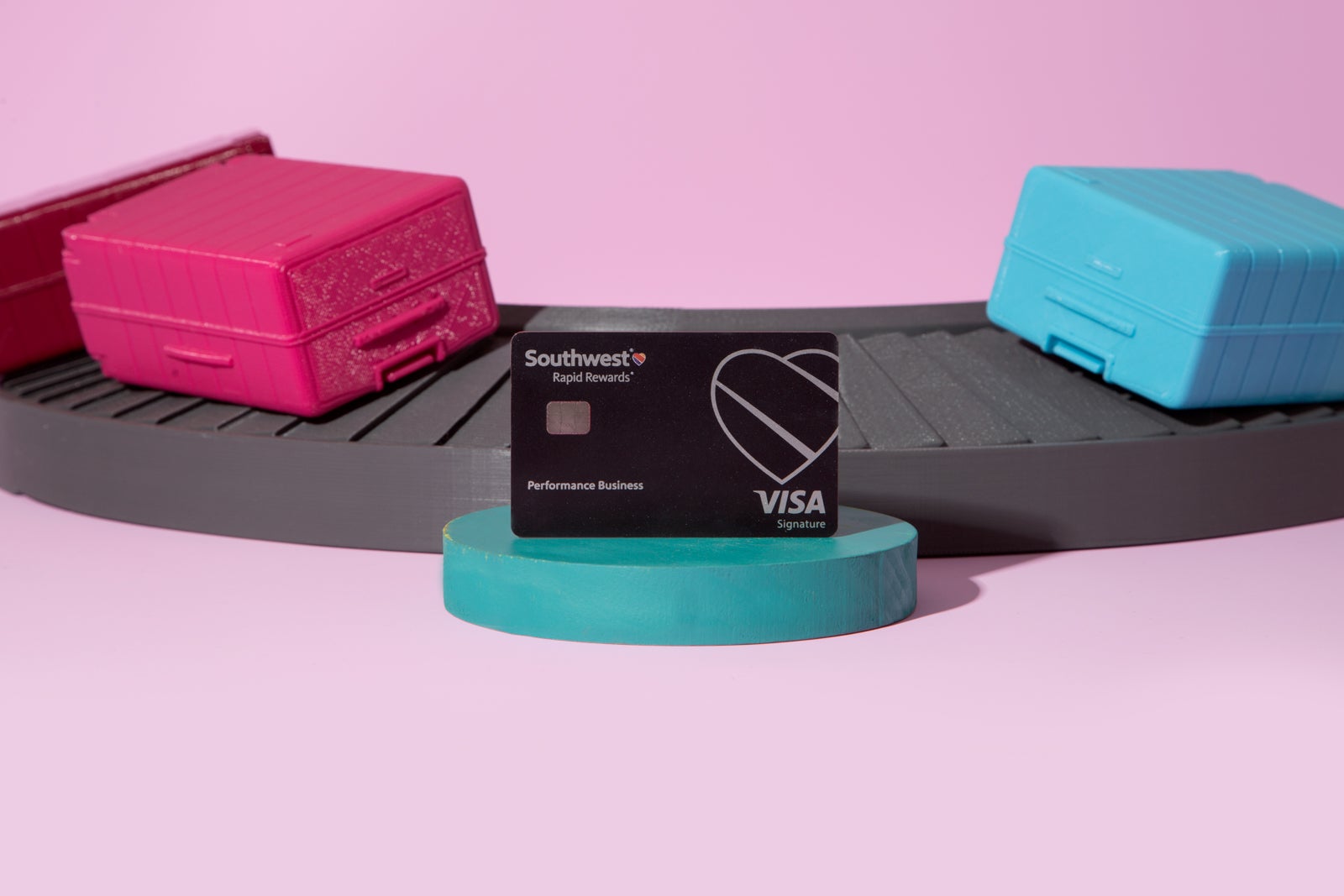 a credit card next to a model of a baggage claim area