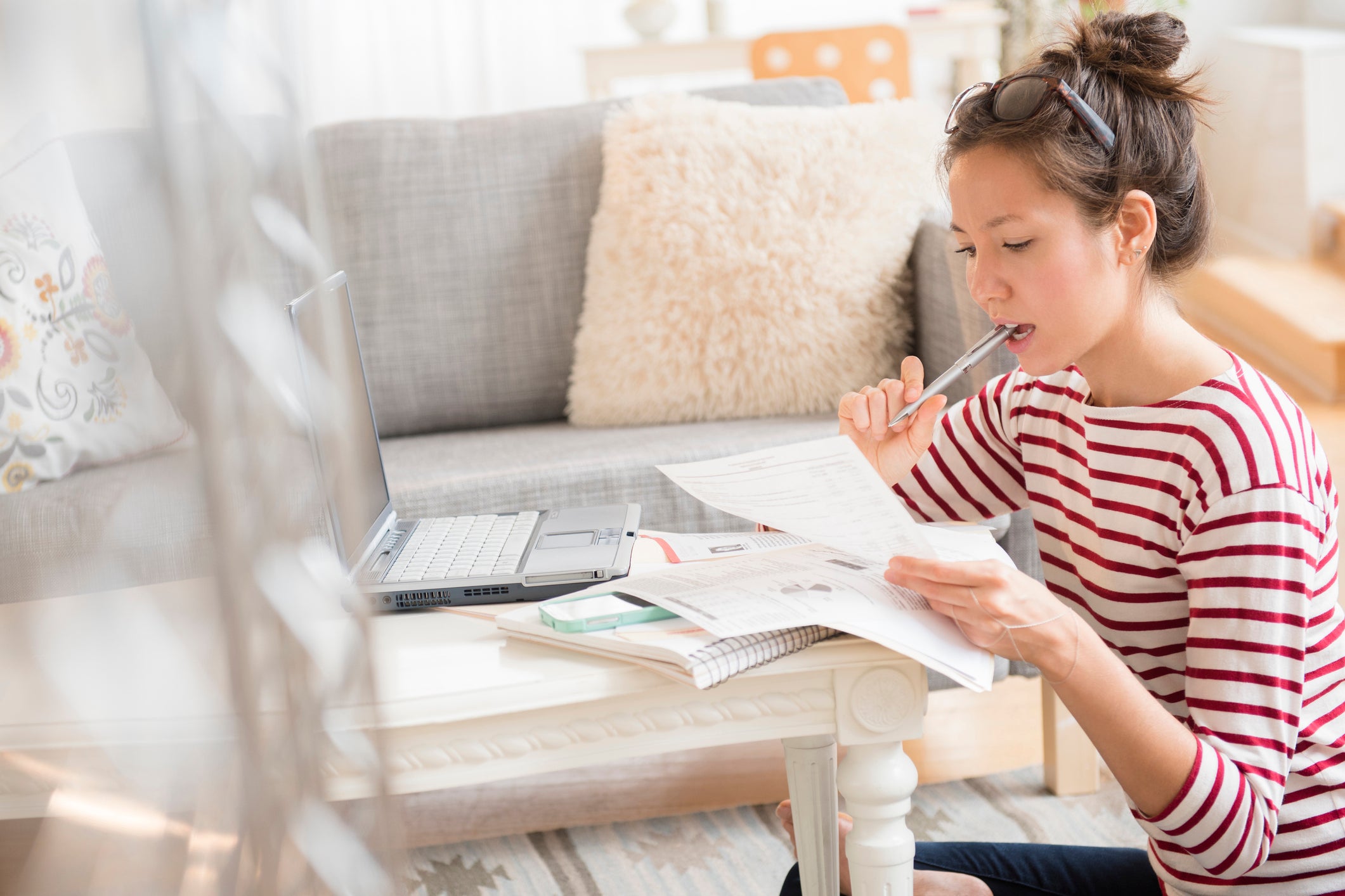 Young woman paying bills on laptop