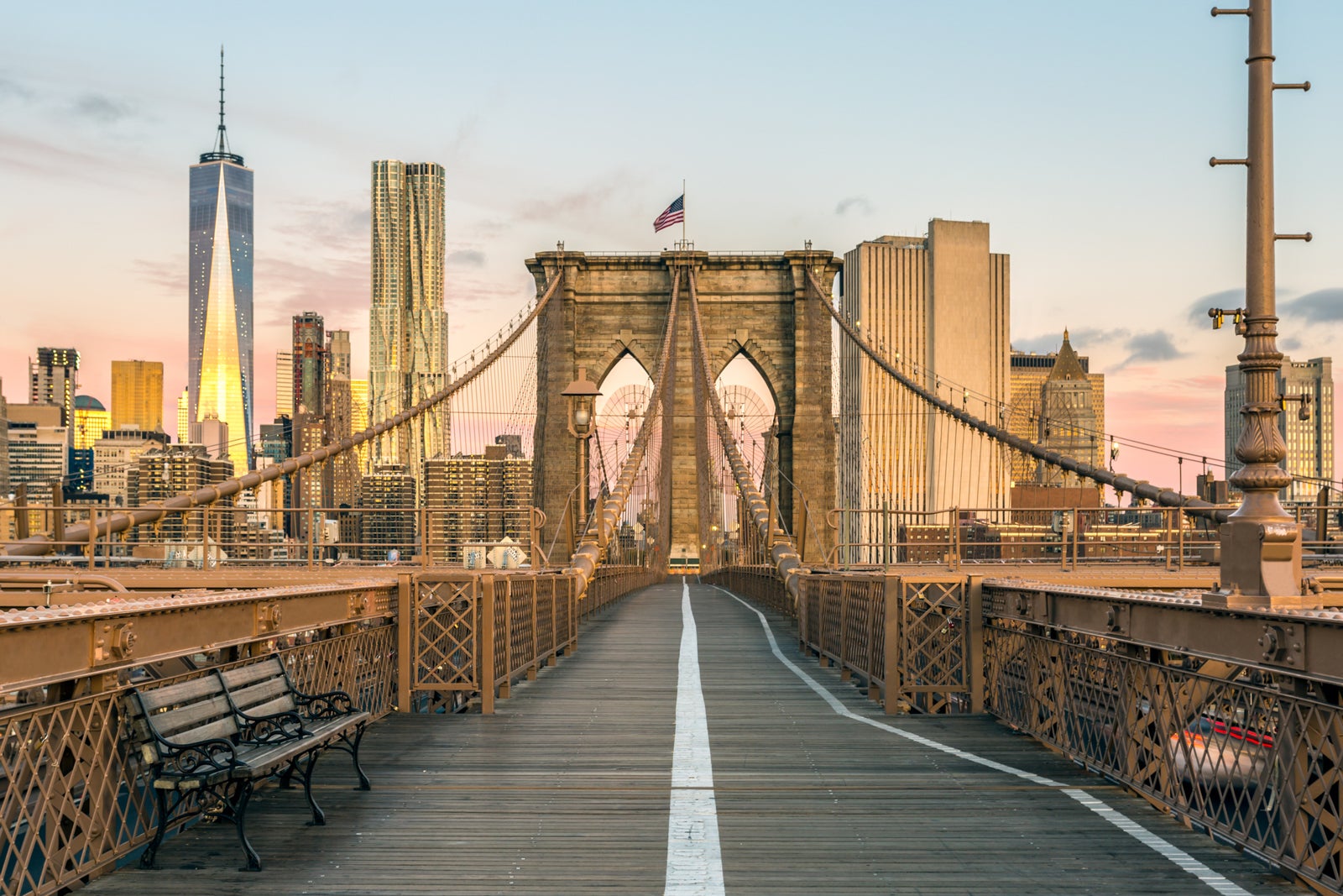 The Brooklyn Bridge looking toward the Manhattan skyline at sunrise in the fall