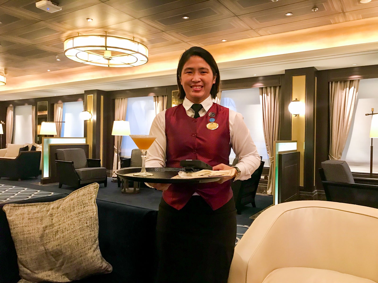 A server on a Princess ship delivers a drink to a customer