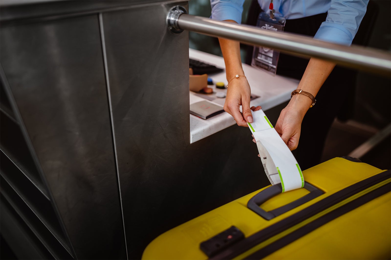 putting a baggage ticket on a suitcase handle