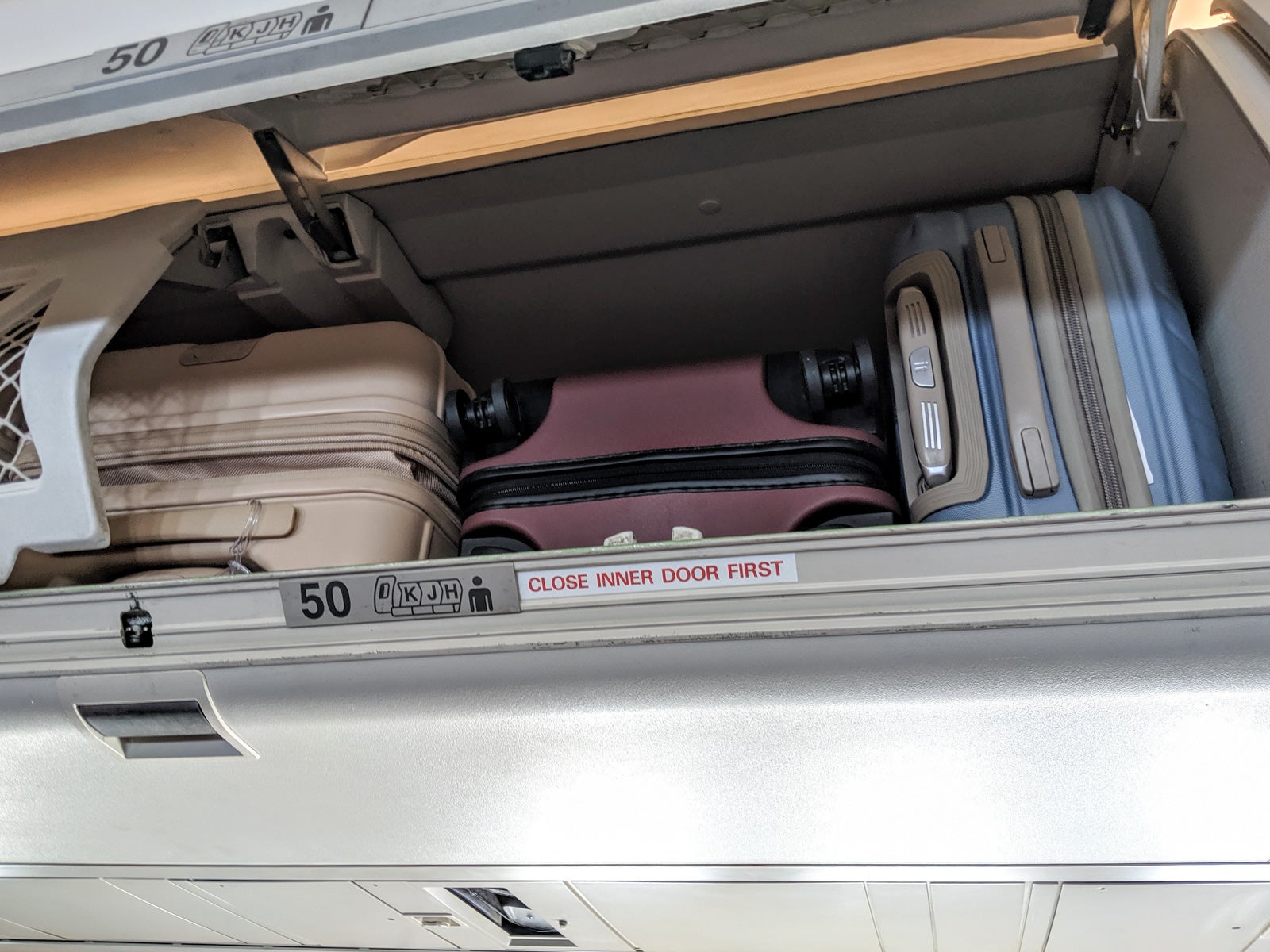 Suitcases in an overhead bin. 