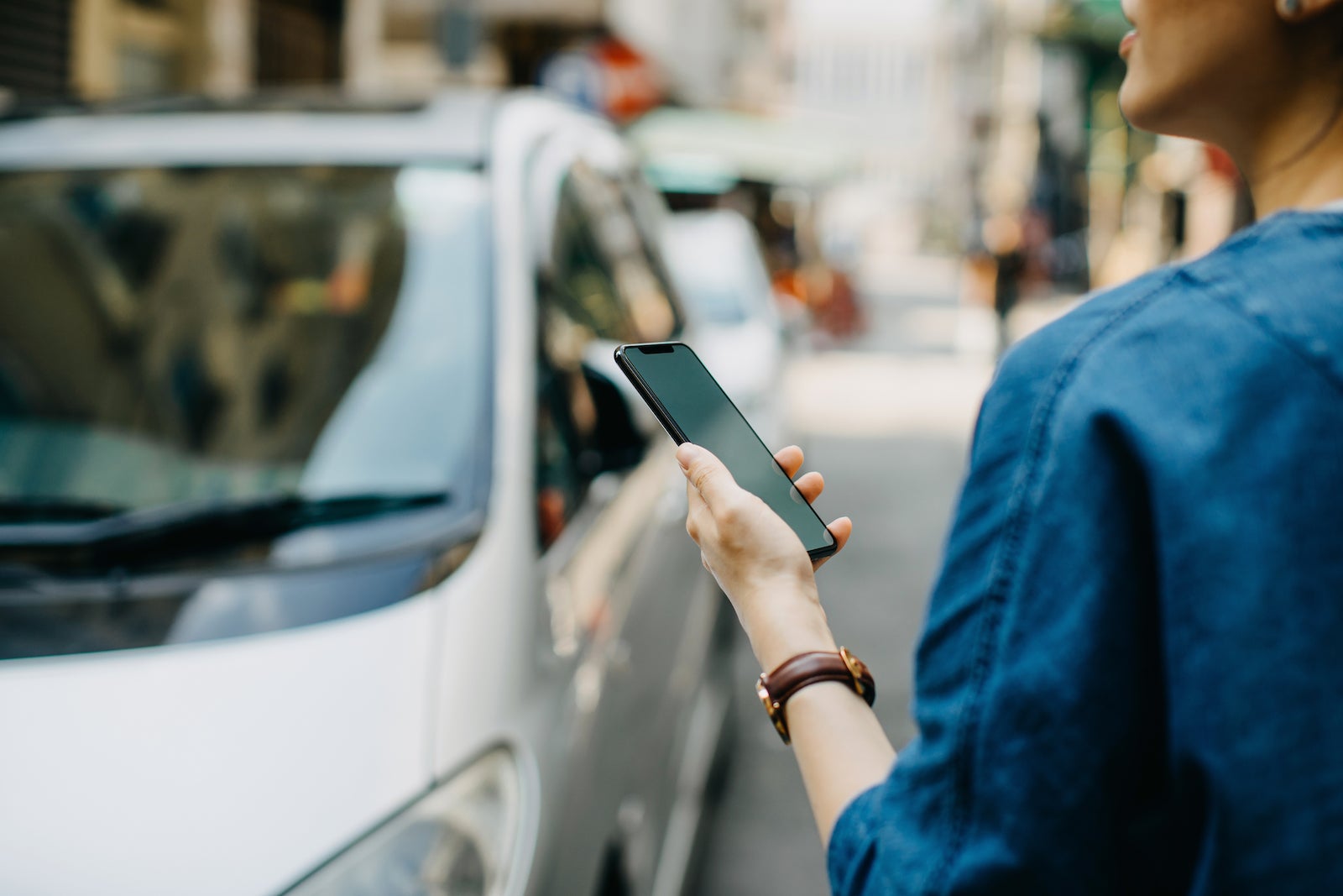 A person holds a phone while ordering from a rideshare app