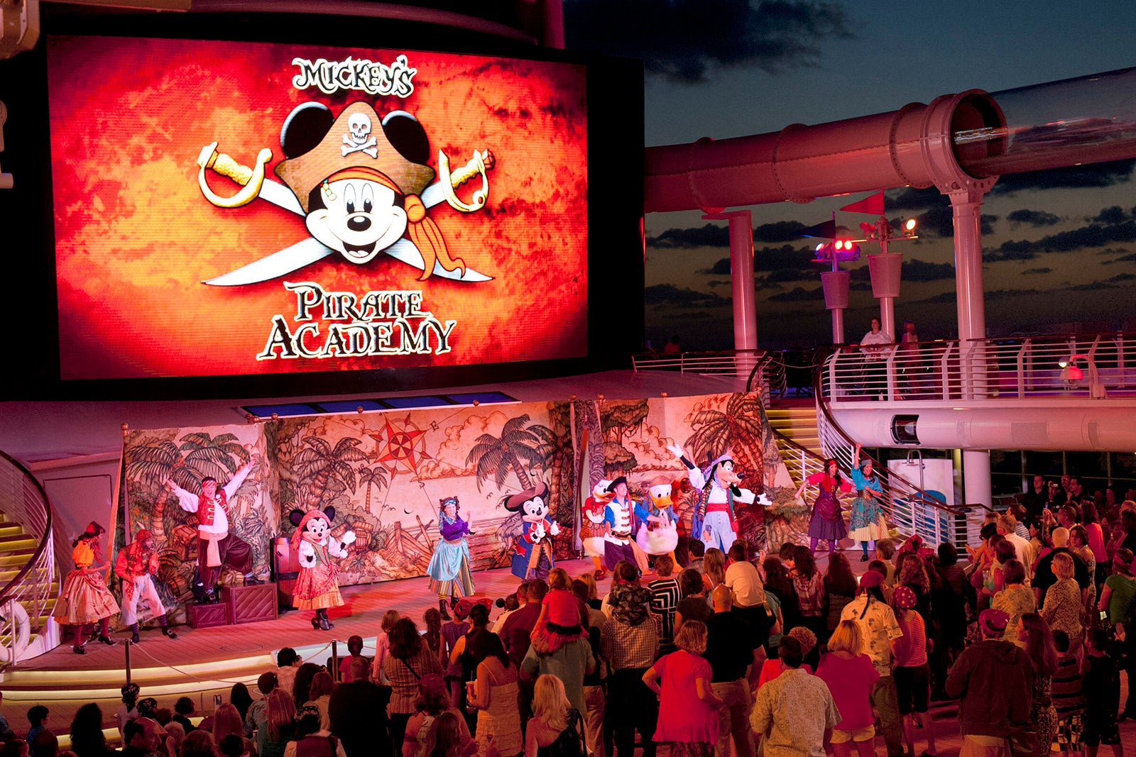 Passengers crowded around the pool deck stage on a Disney Cruise Line ship