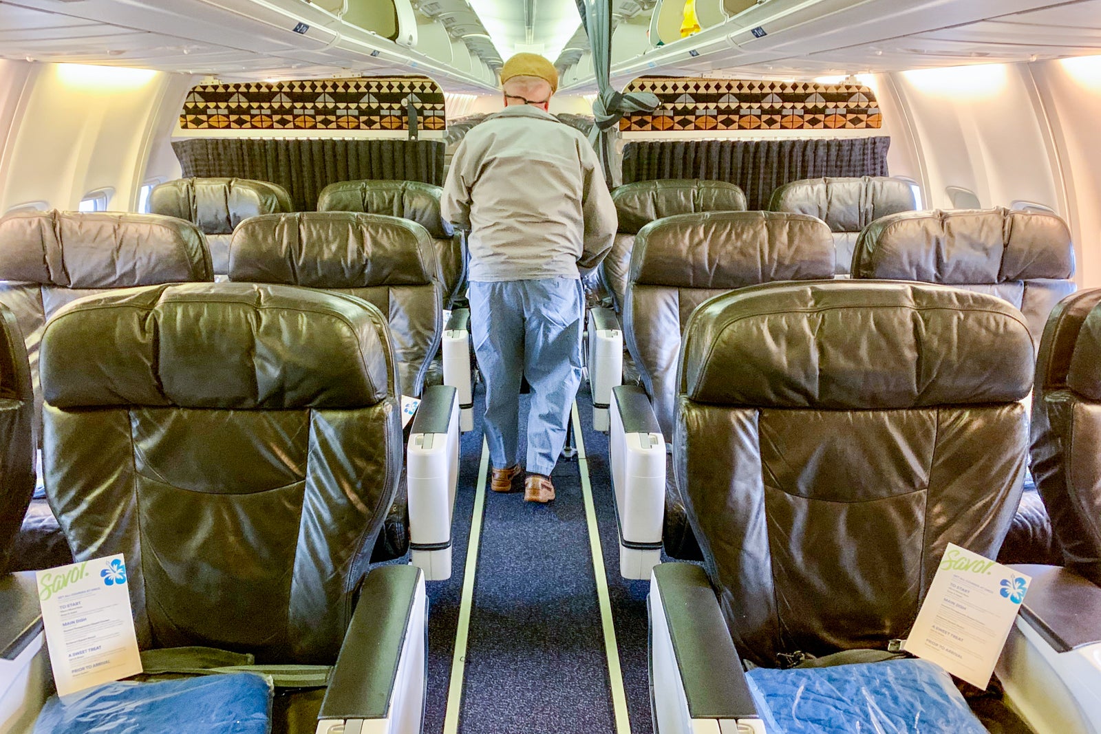 A person walking down the aisle of an Alaska Airlines plane