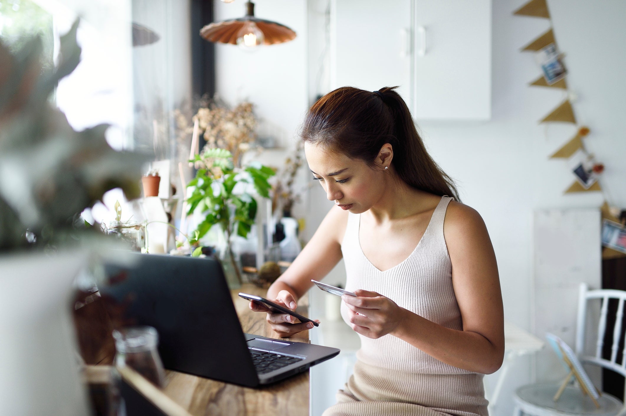 Woman entering credit card number into laptop