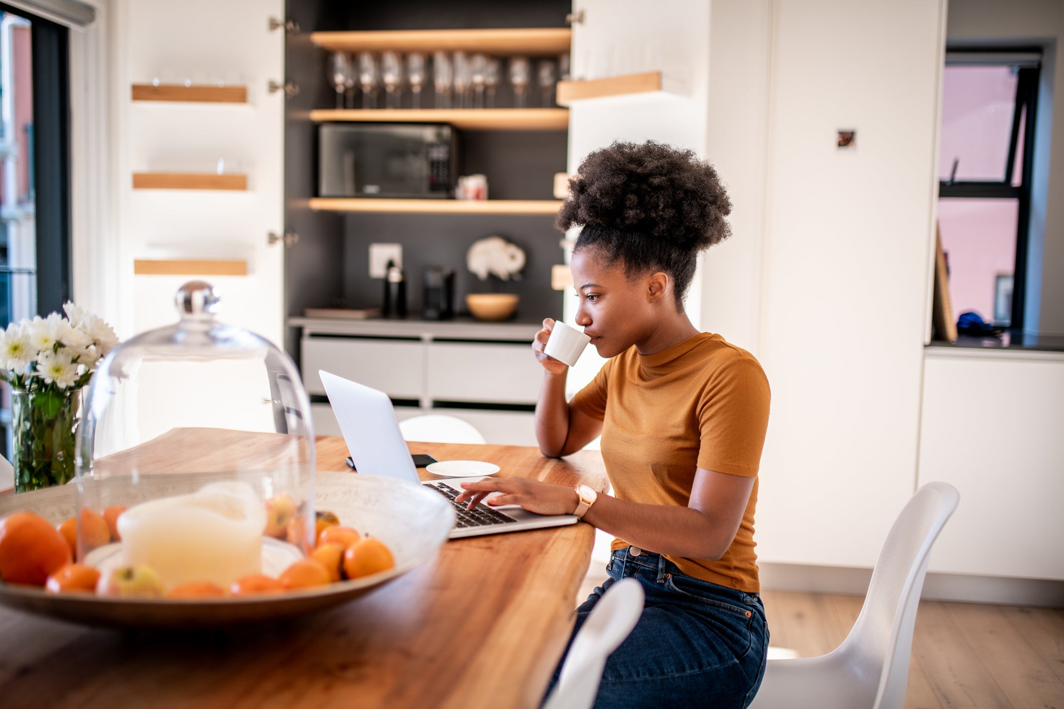 Woman working on computer and drinking coffee