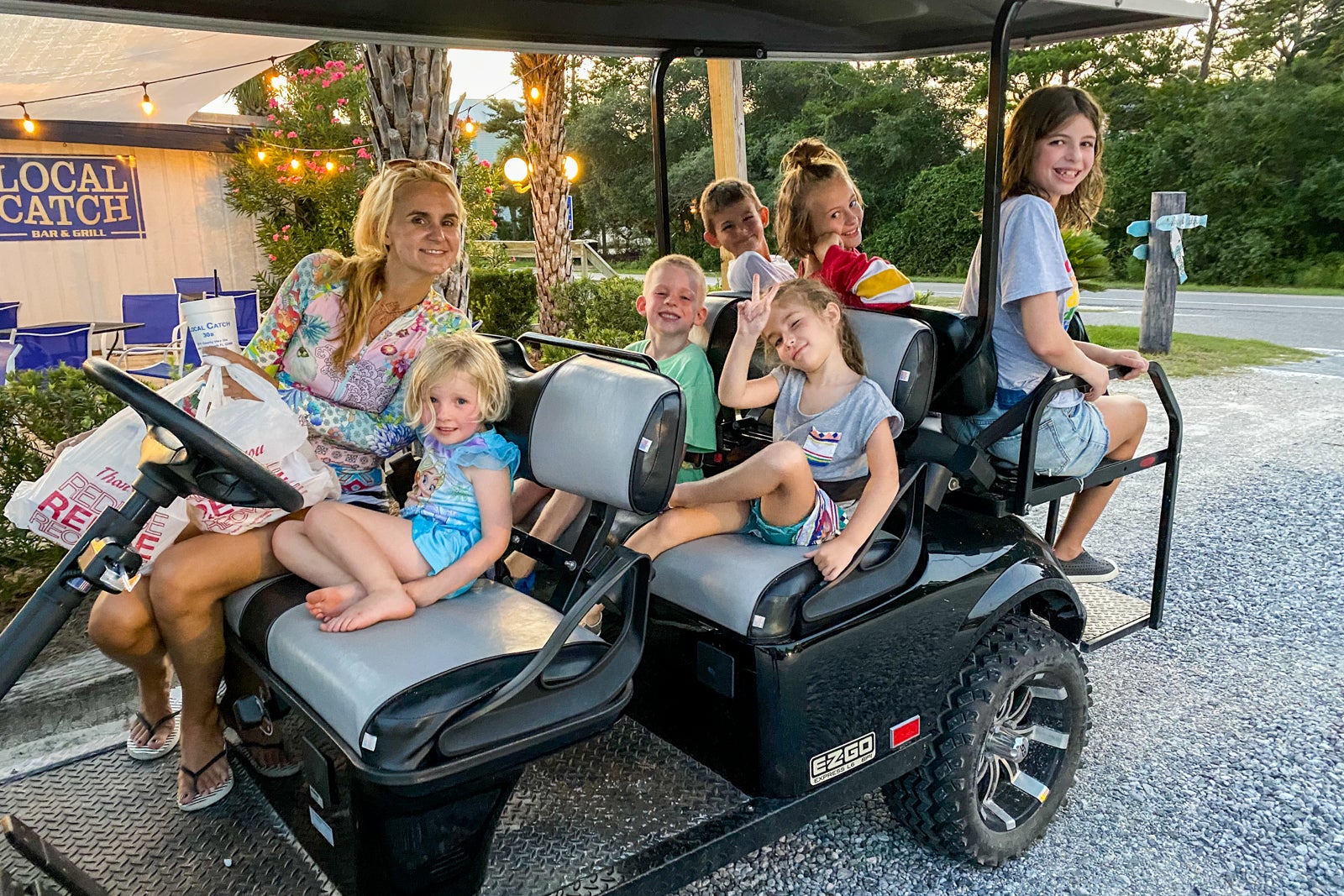 A mother and kids on a golf cart