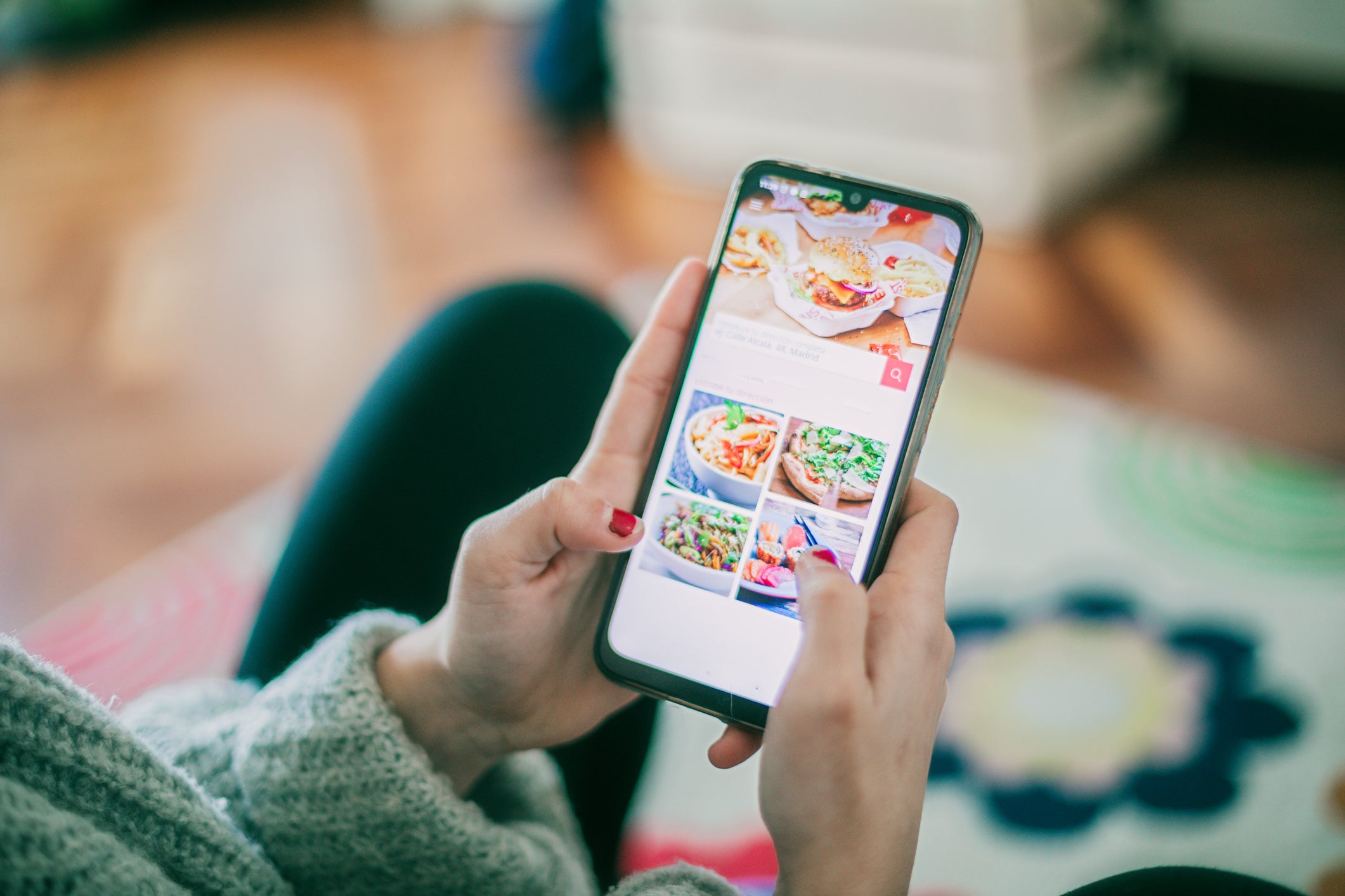 an unseen person uses a smartphone app to order food online