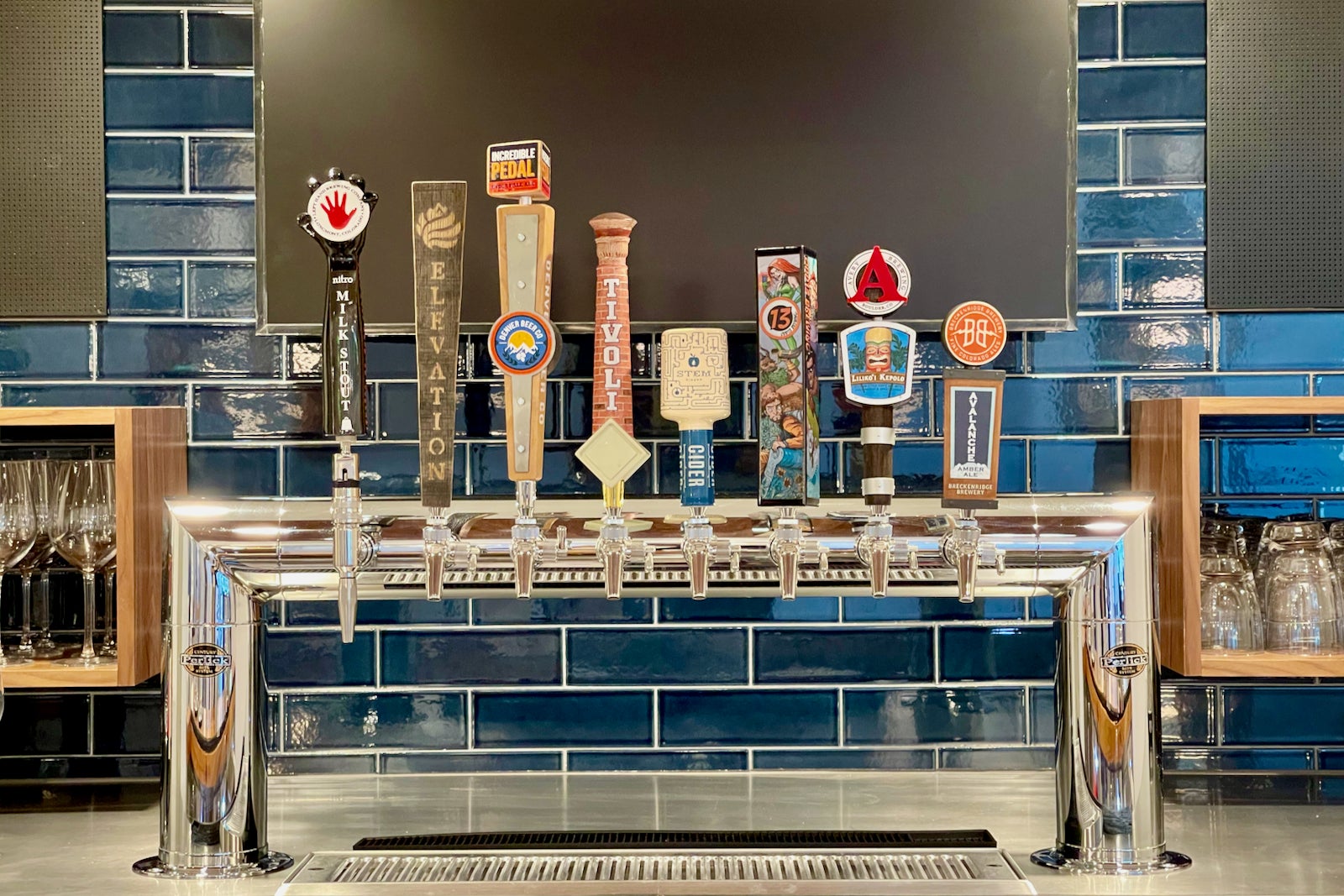 tap handles with logos for beers available at a bar