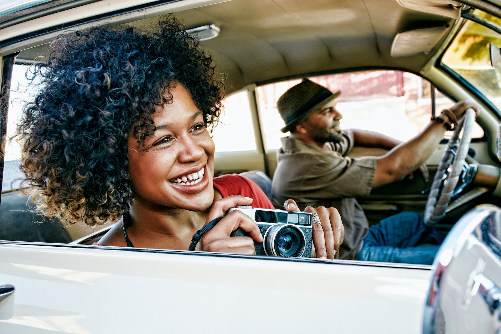 woman taking photos from passenger seat while man drives