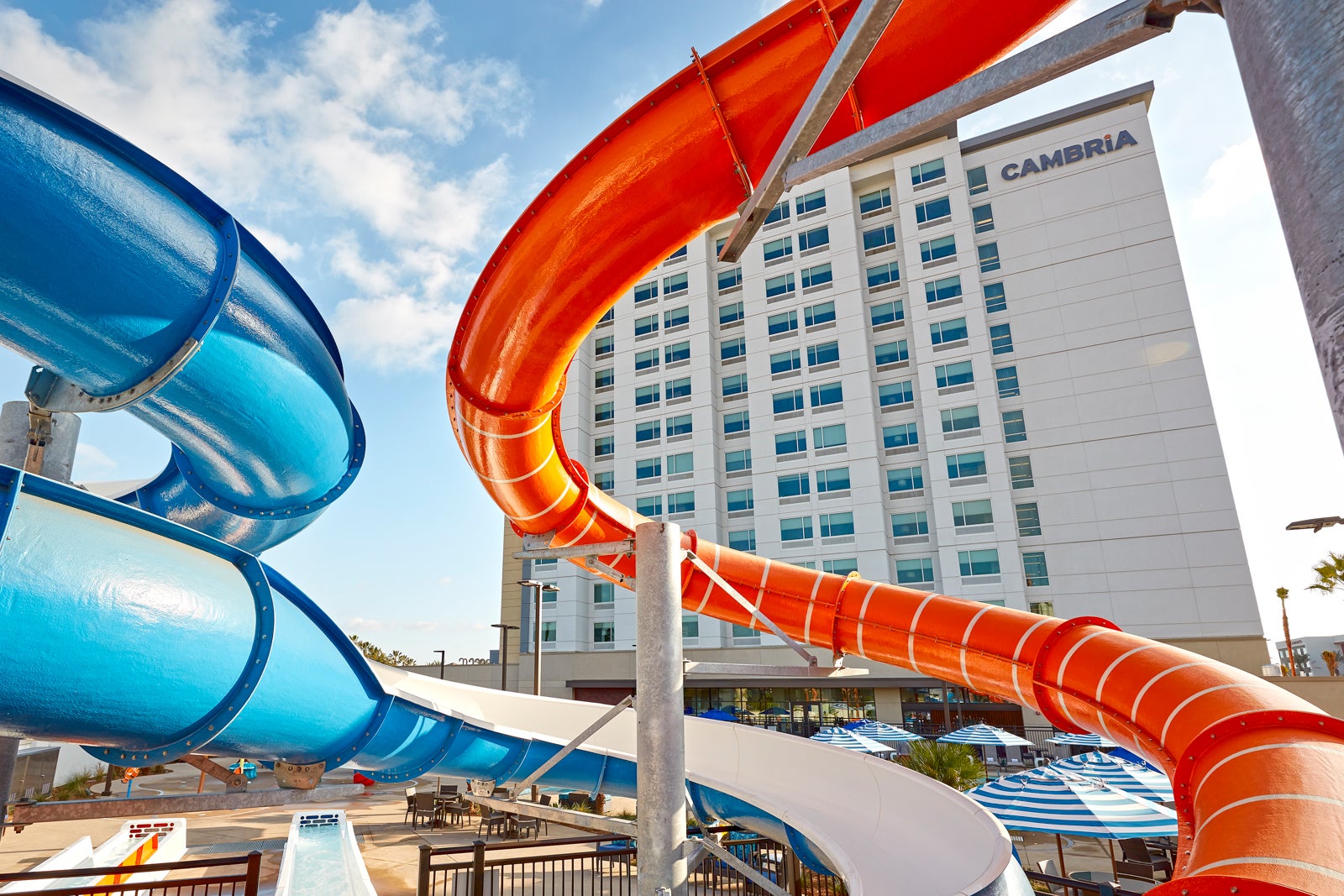 blue and red waterslides in front of a white hotel building