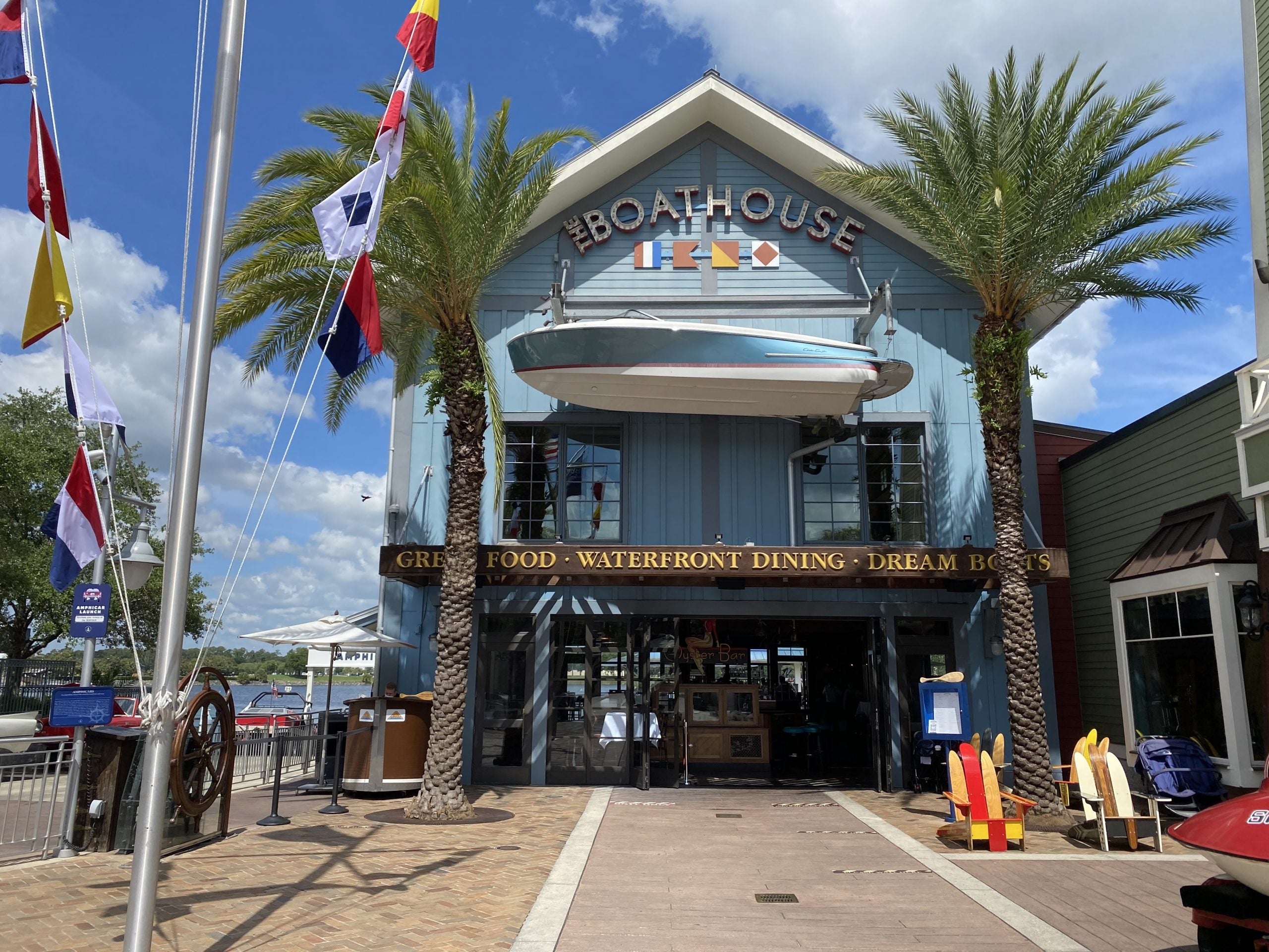 A boat hangs above the entrance of the blue Boathouse restaurant at Disney Springs