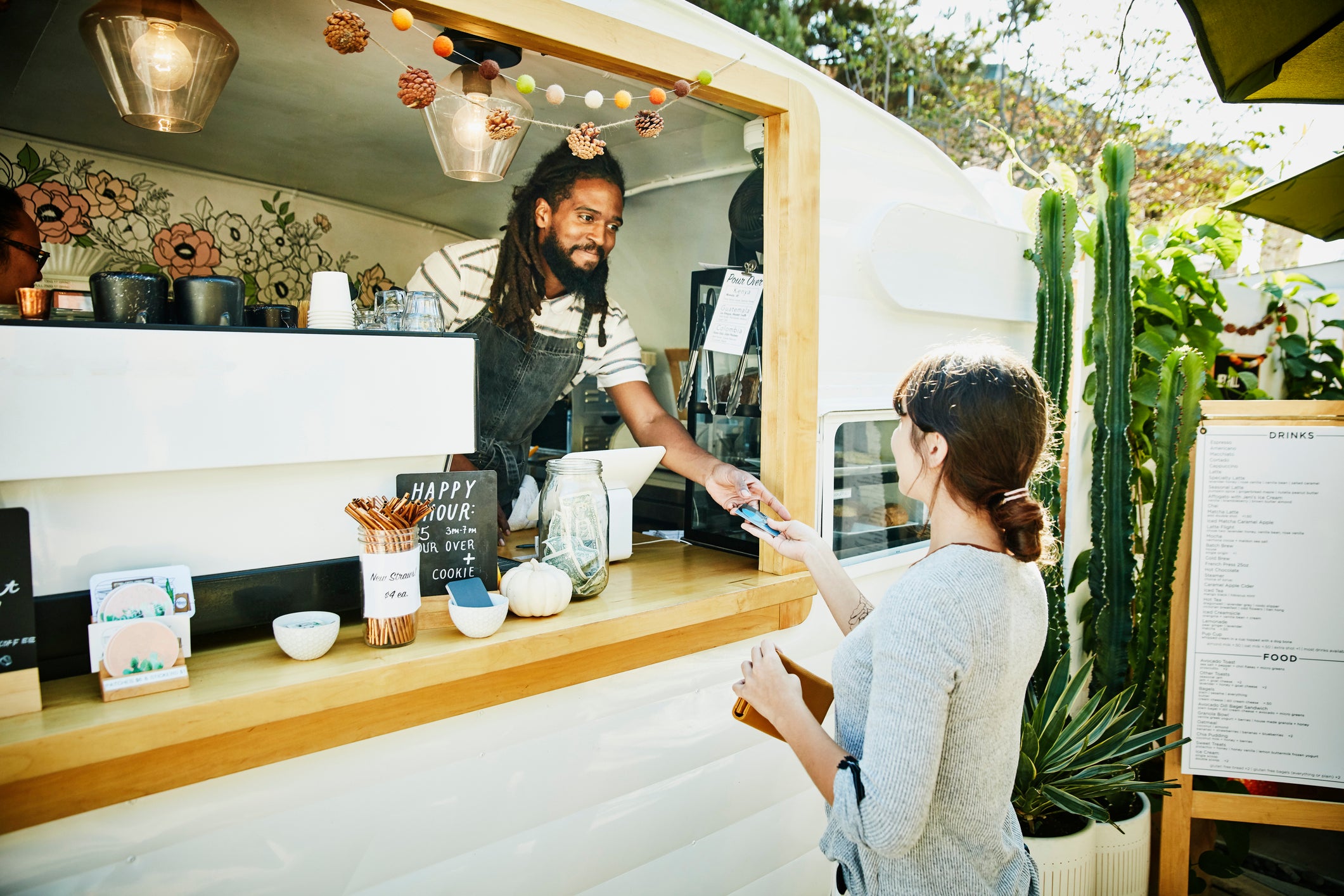 Small business owner hands card back to customer.