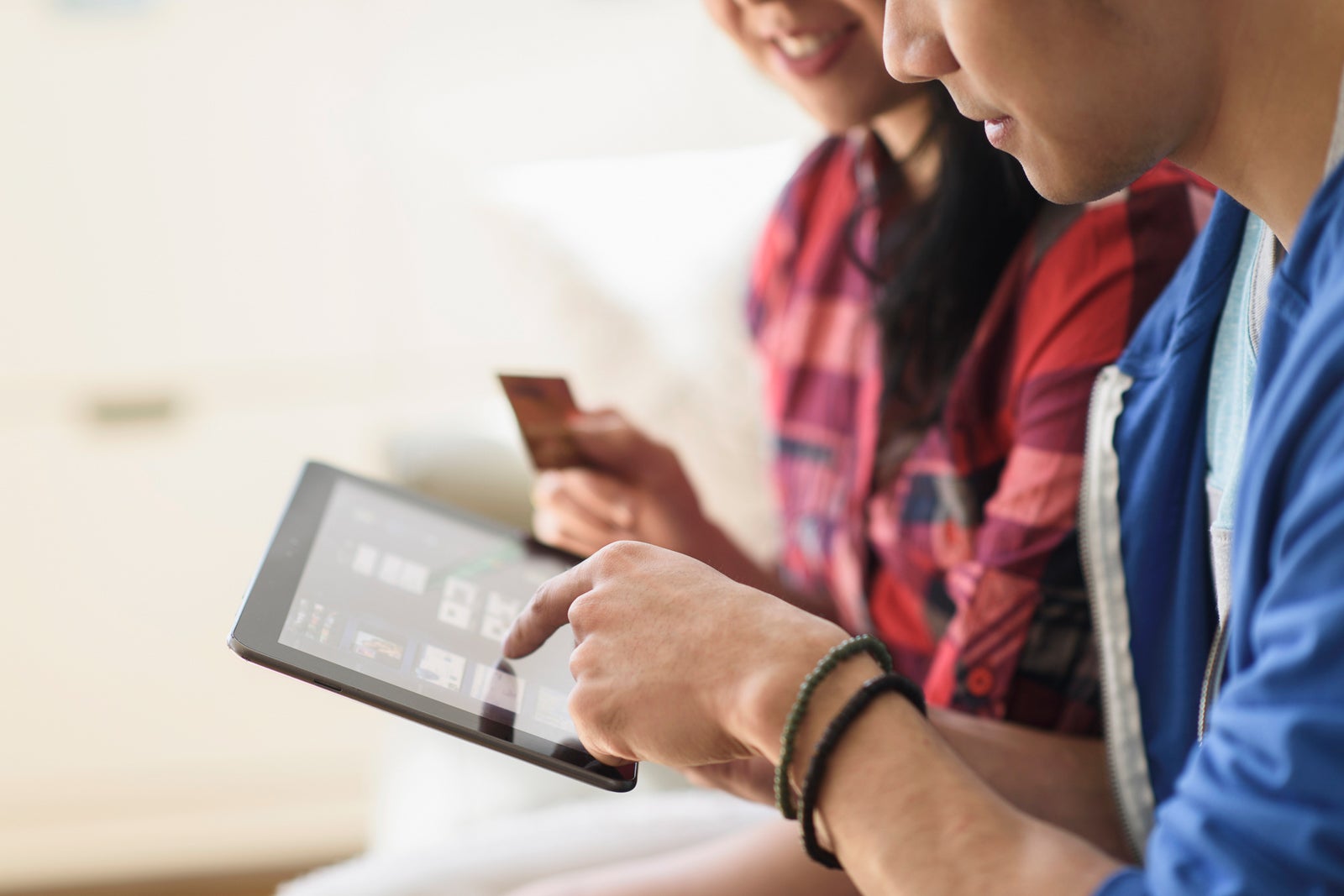 2 people use a tablet for online shopping