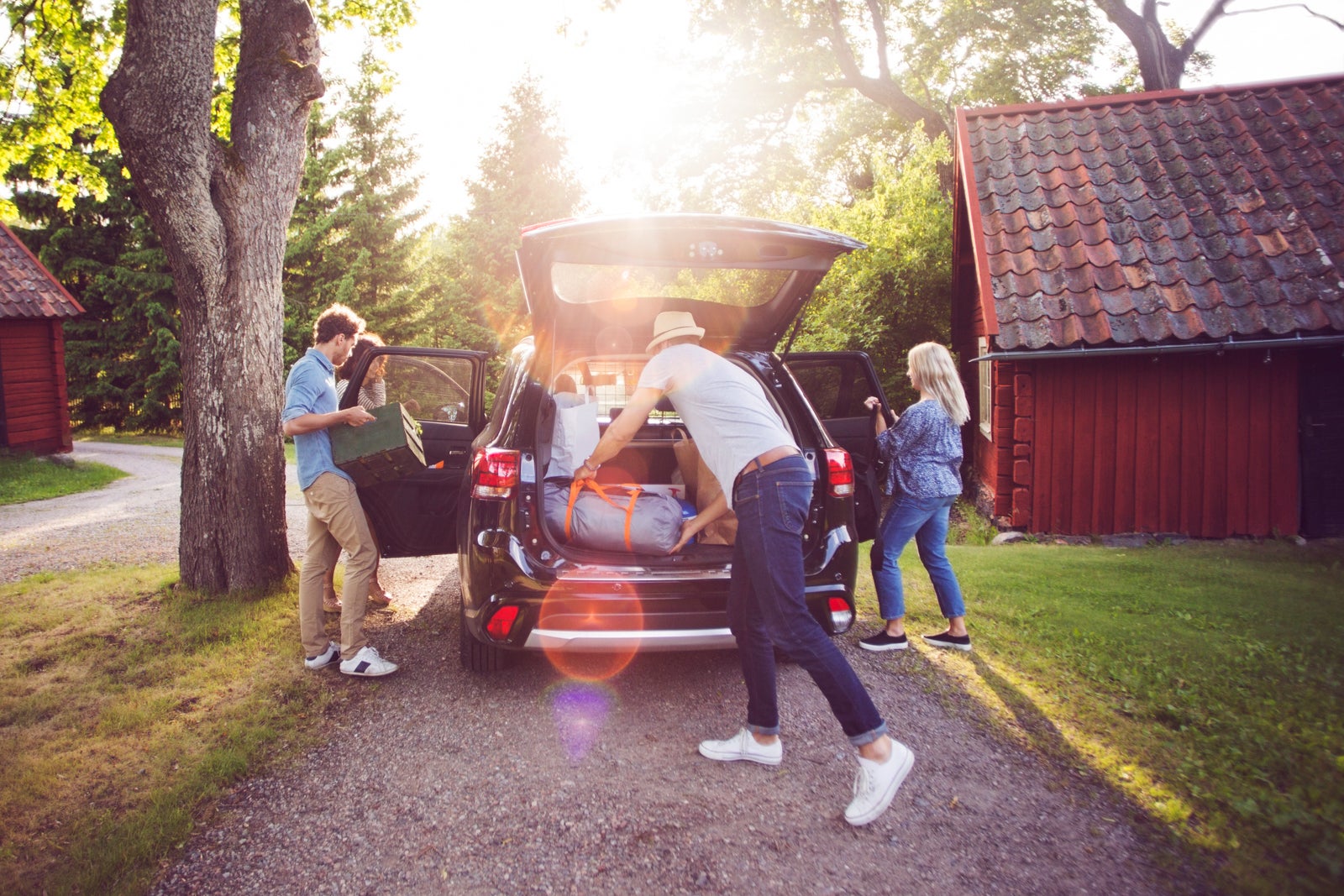 Family packing gear into a rental car