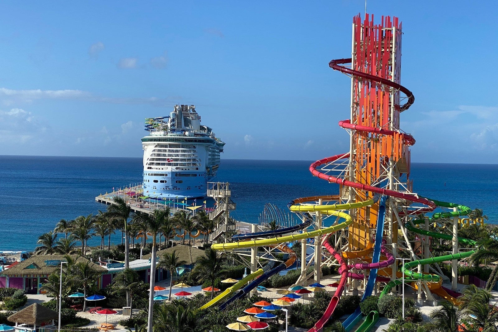 Cruise ship near to tall water slide tower.