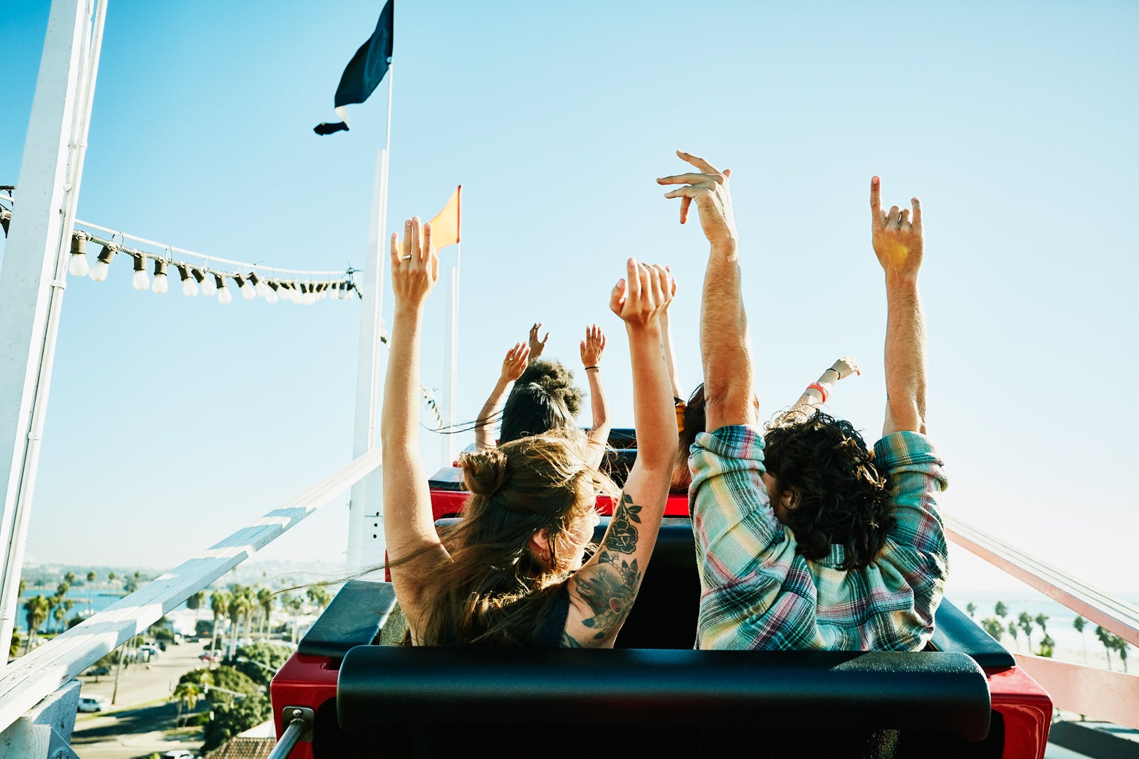 photo of people with their hands in the air while riding a class rollercoaster