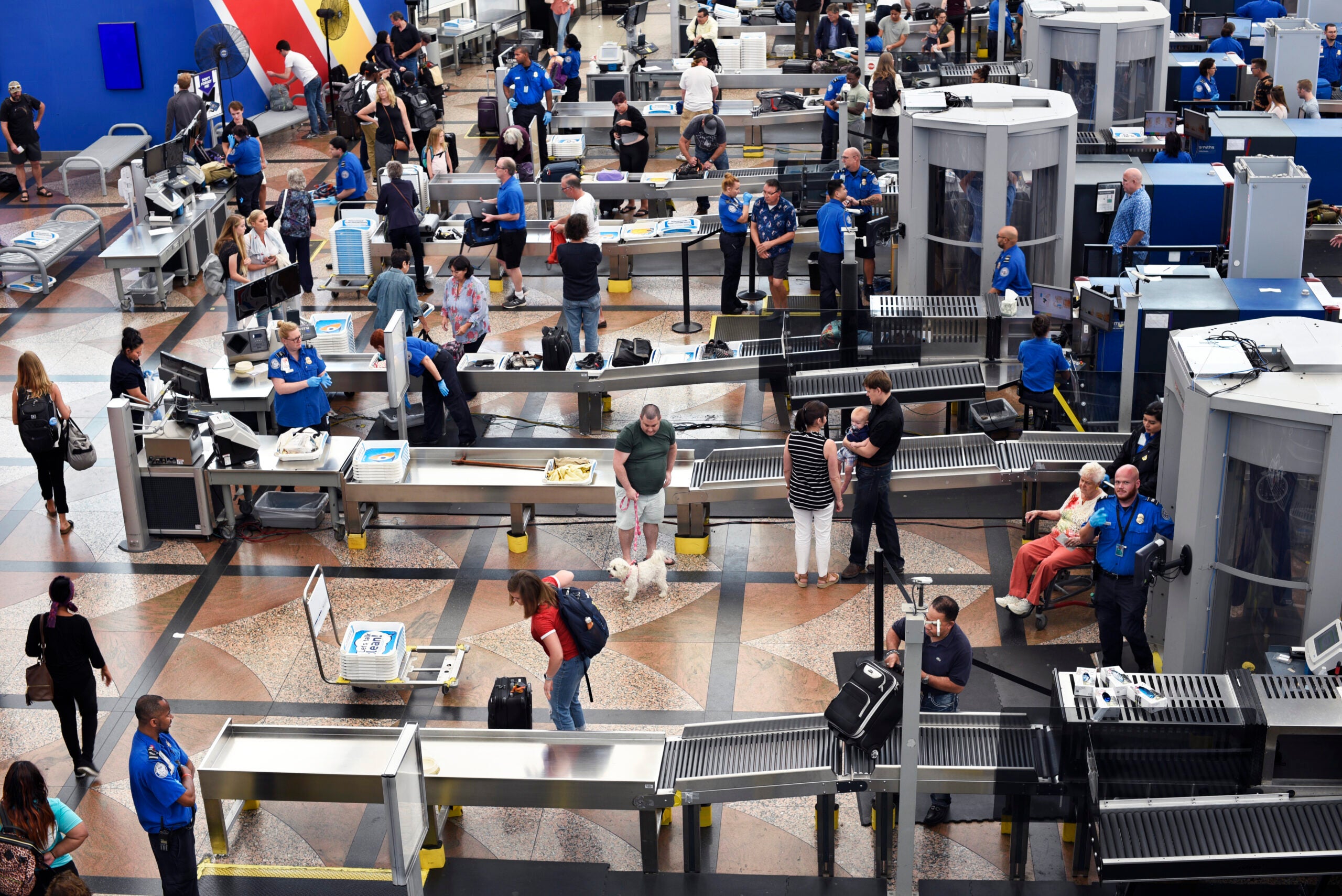 Passengers proceed through the TSA security checkpoint at Denver International Airport