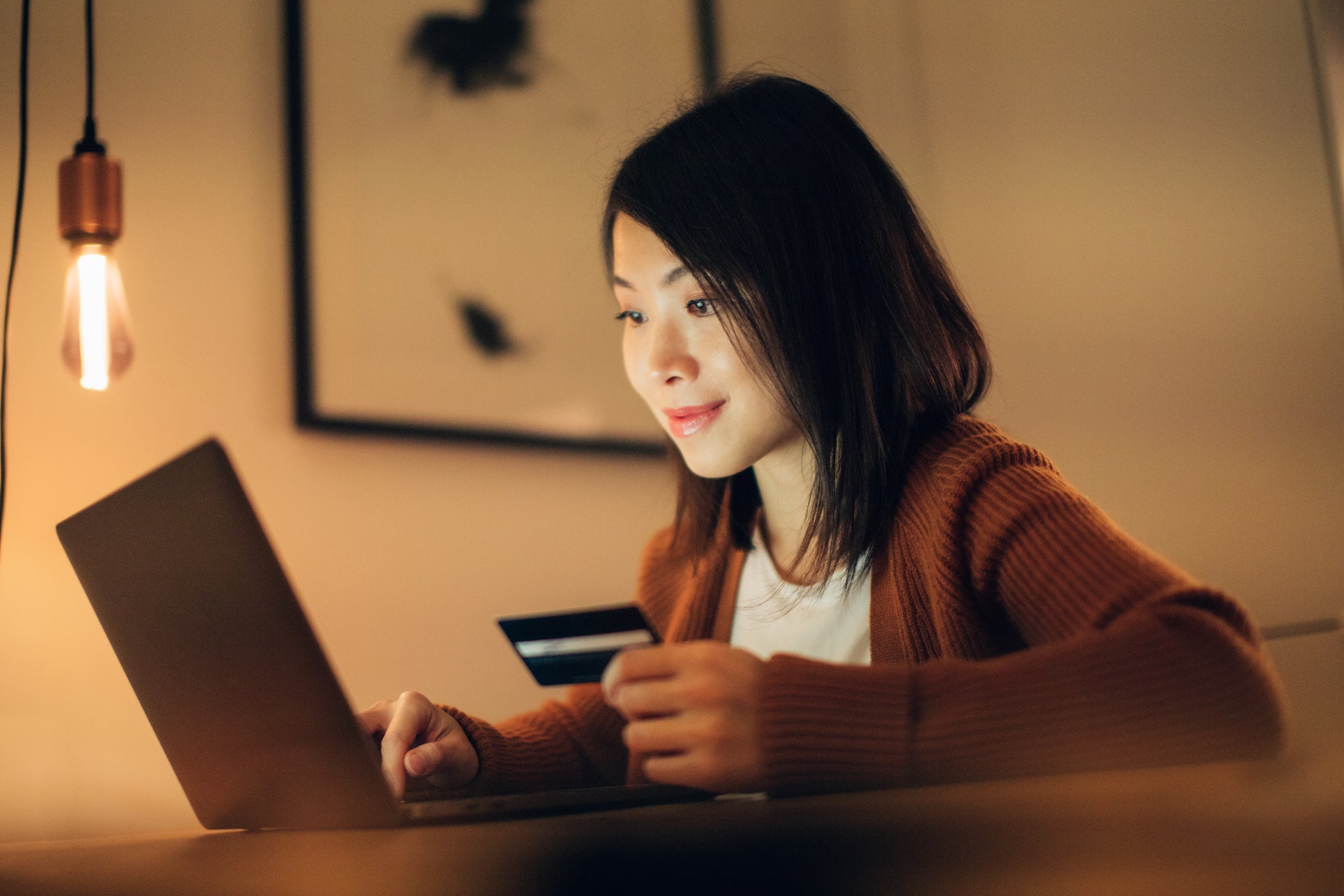 Young Woman Shopping Online With Laptop And Credit Card At Home