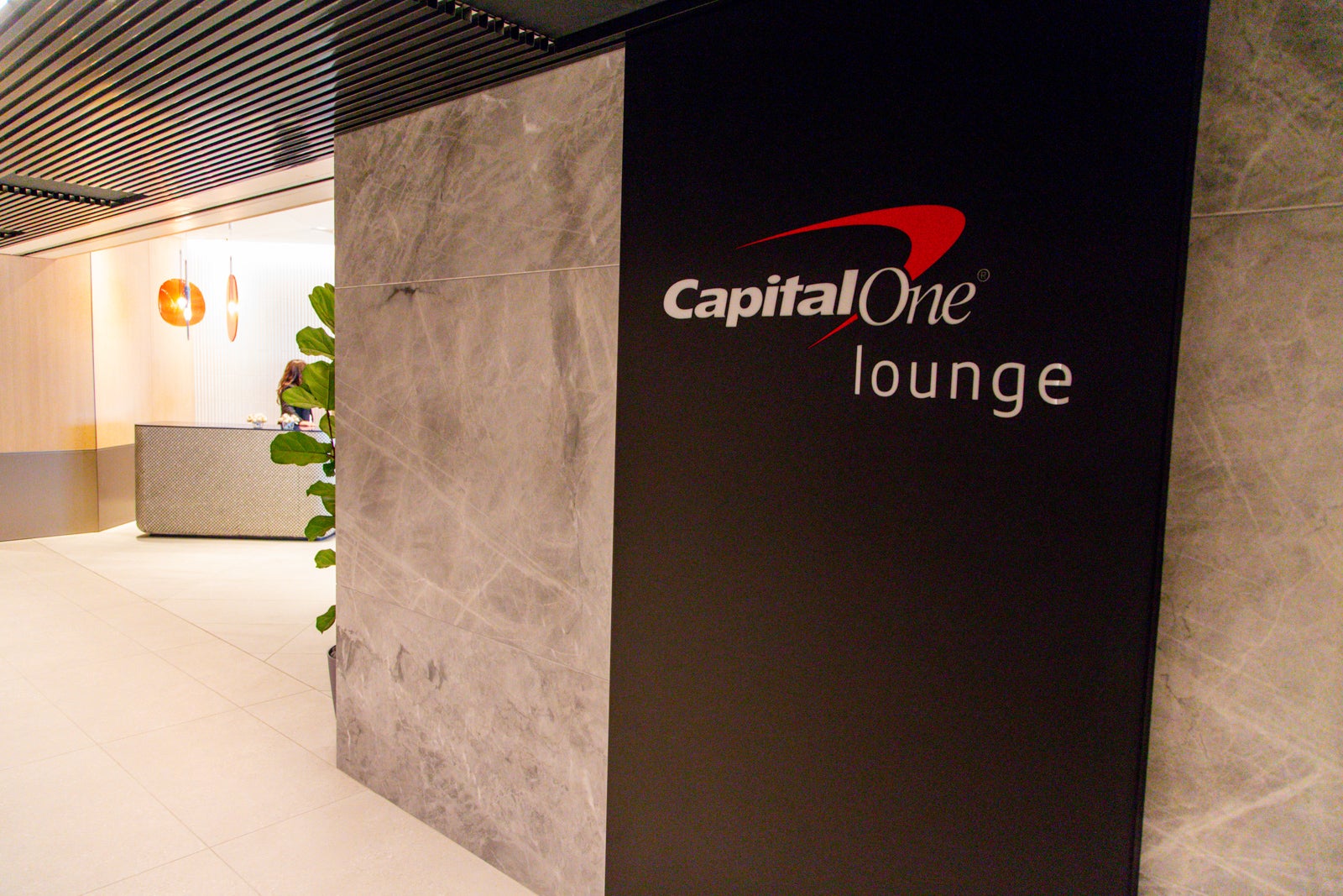 Photo shows signage leading to a Capital One lounge further down the hall