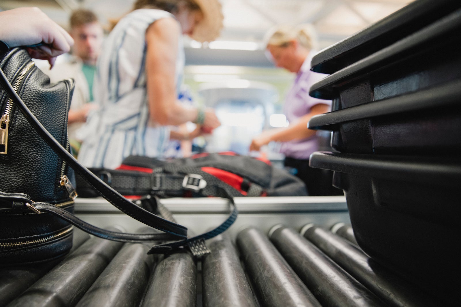 Passengers preparing their bags for airport security checkpoints