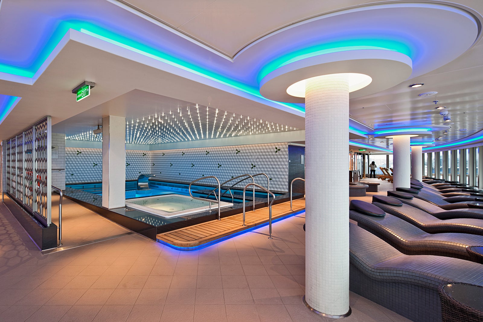 A cruise ship spa's thermal suite area, featuring a heated pool and tile loungers