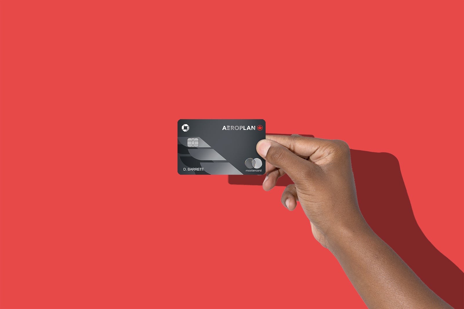 a hand holds the Aeroplan Credit Card against a red background