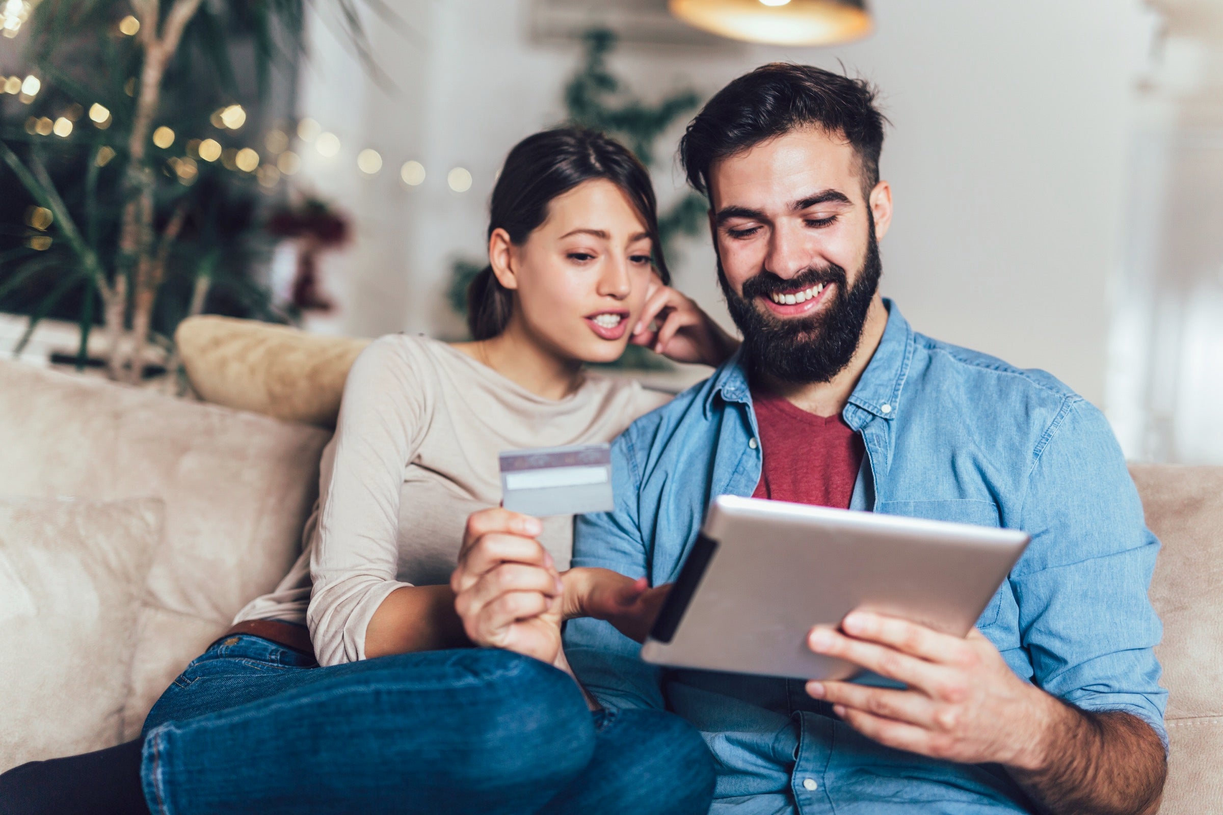 Couple using an iPad while holding a credit card