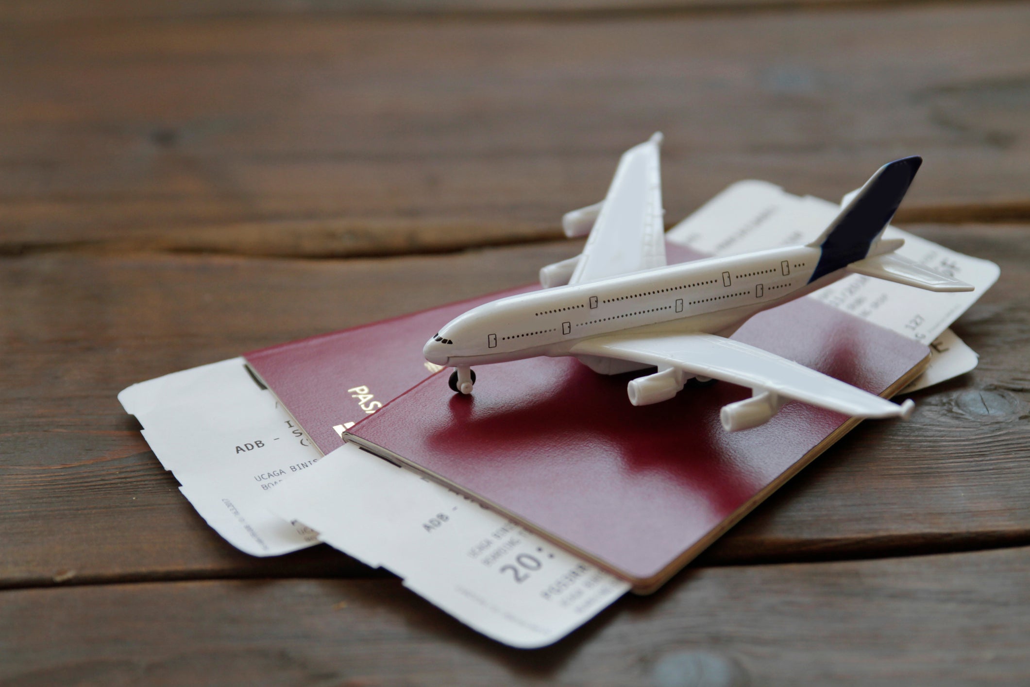 a toy airplane sits on top of passports and boarding passes