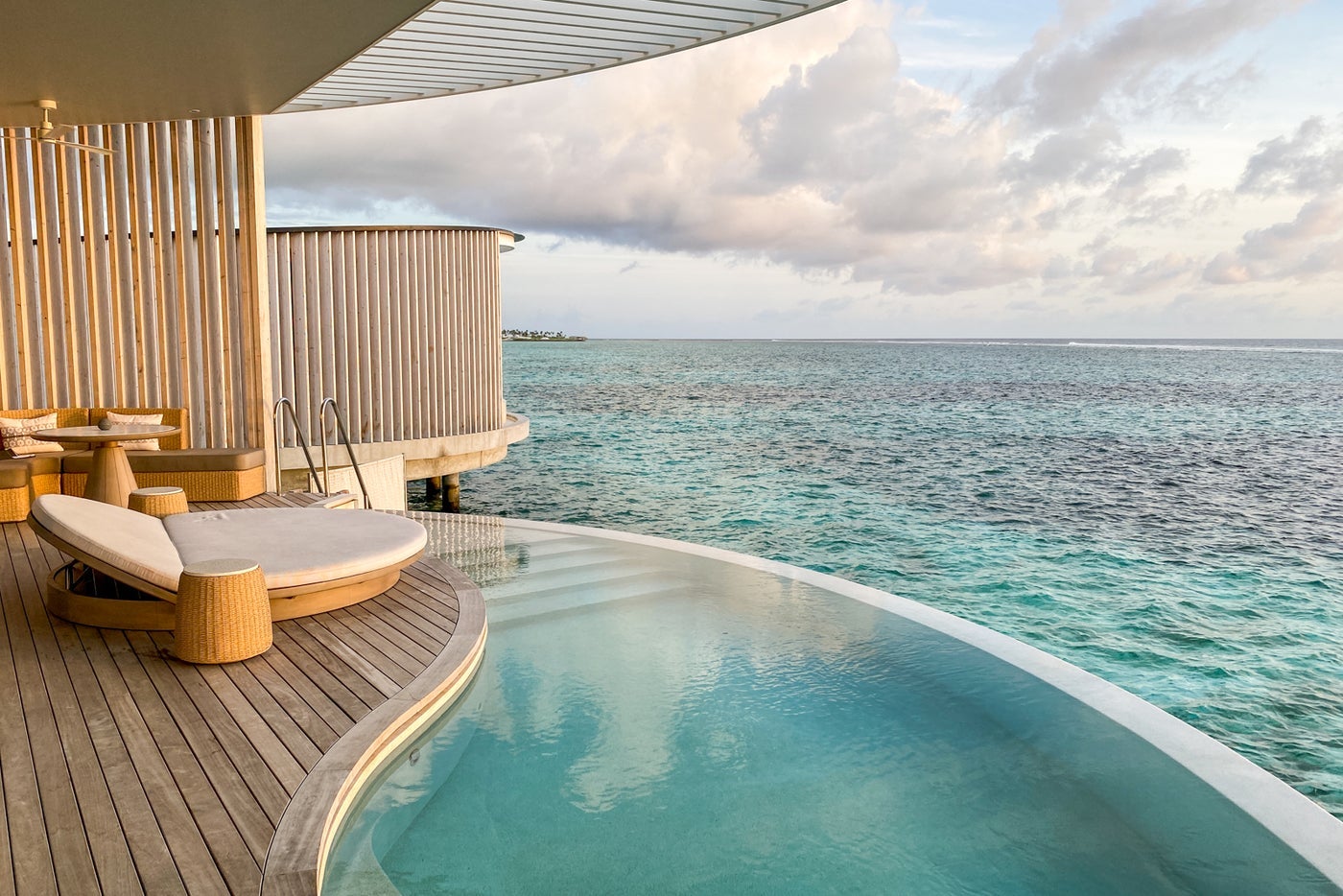 plunge pool on wooden deck overlooking clear, blue waters