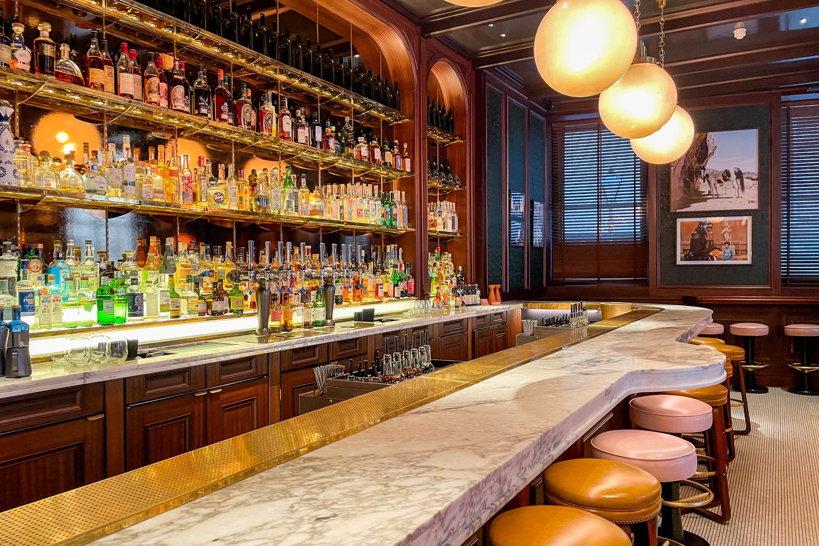 a hotel bar with wood paneling and a marble counter