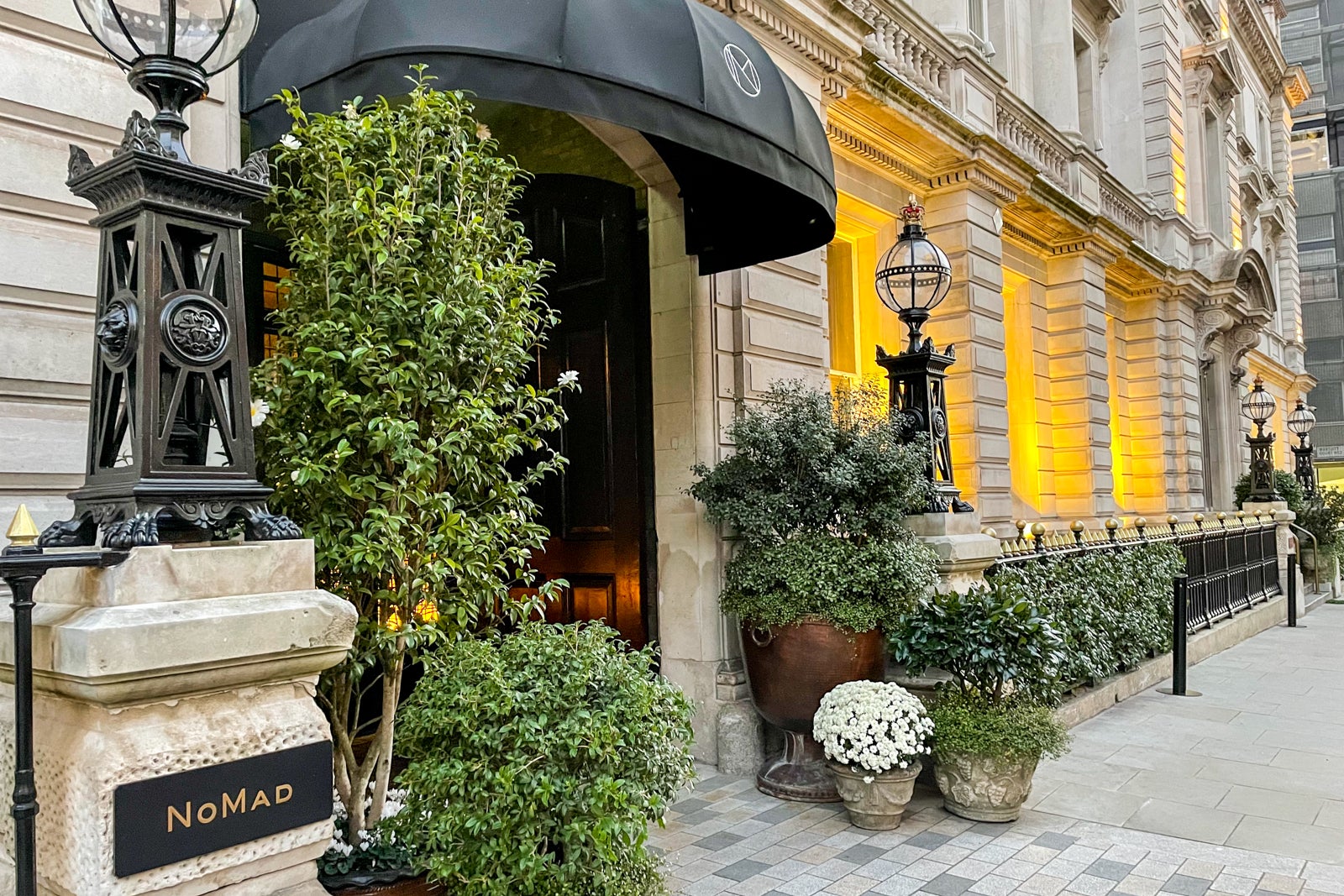 a neoclassical building with a black awning over the door