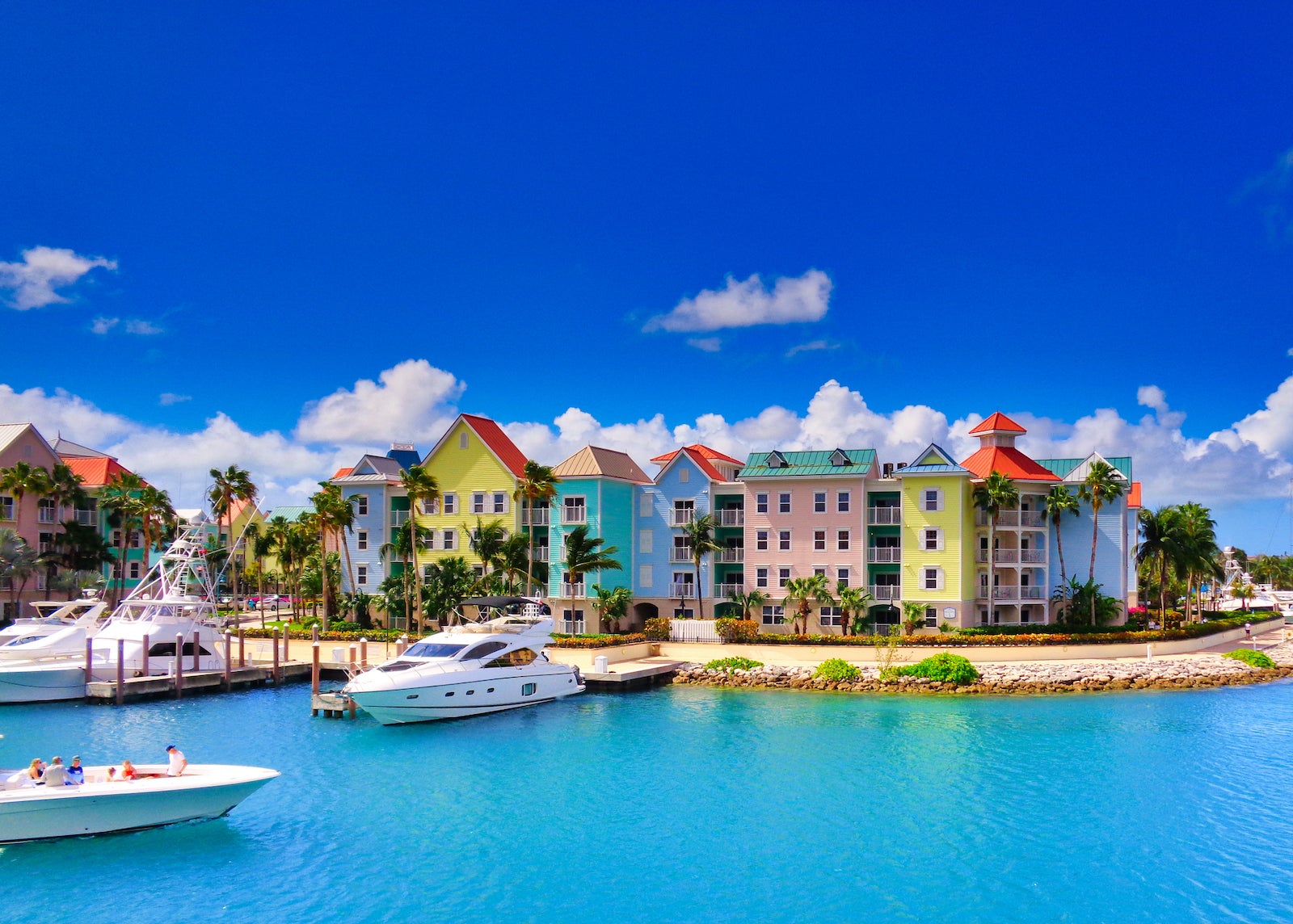 Colorful houses line teal water under a blue sky in Nassau, Bahamas