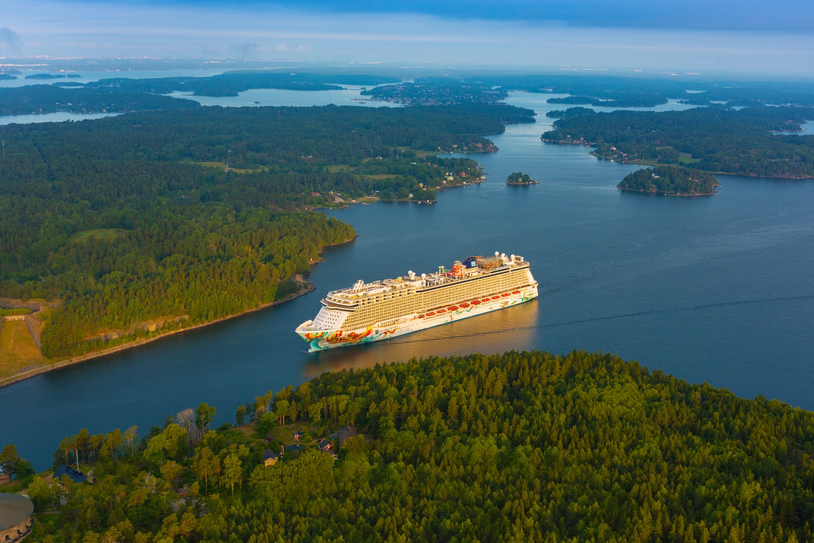 Norwegian Getaway sailing between forested islands