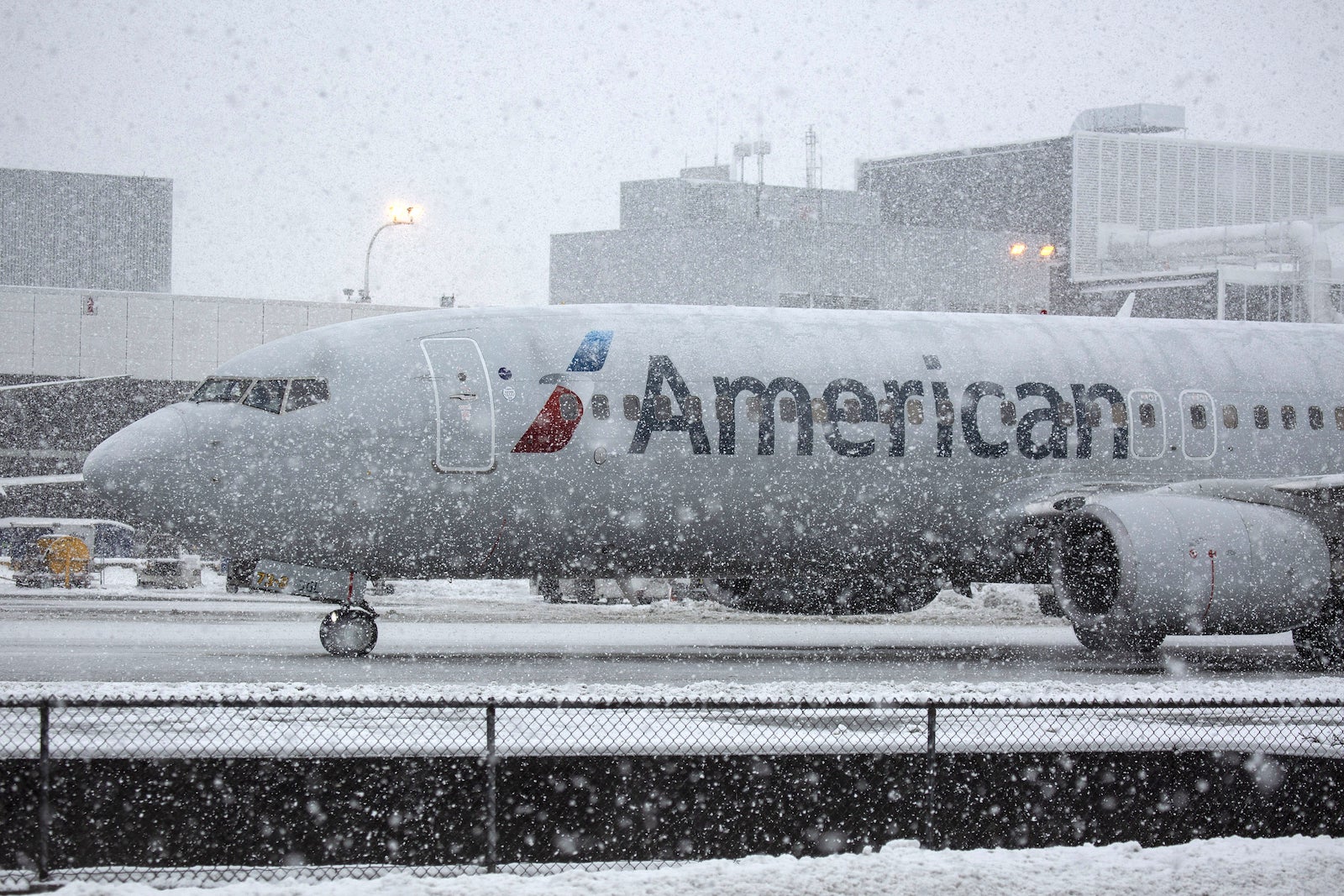 An American Airlines Group Inc. plane is seen during snowfall at the Seattle-Tacoma International Airport (SEA) in Seattle, Washington, U.S., on Monday, Feb. 11, 2019. The National Weather Service reports that Seattle-Tacoma International Airport has received 14.1 inches of snow so far in February, more than twice the annual average and the snowiest month in more than 30 years, according to the Associated Press. Photographer: David Ryder/Bloomberg