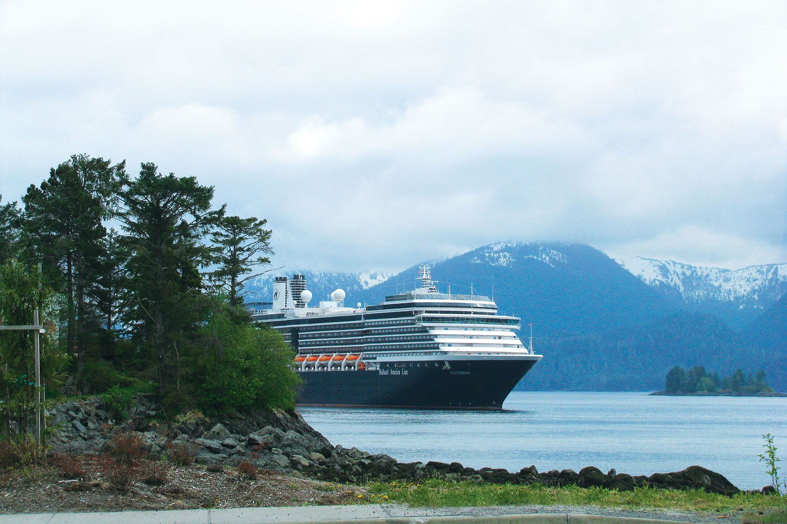 Holland America cruise ship passing by mountains and forest in Sitka, Alaska