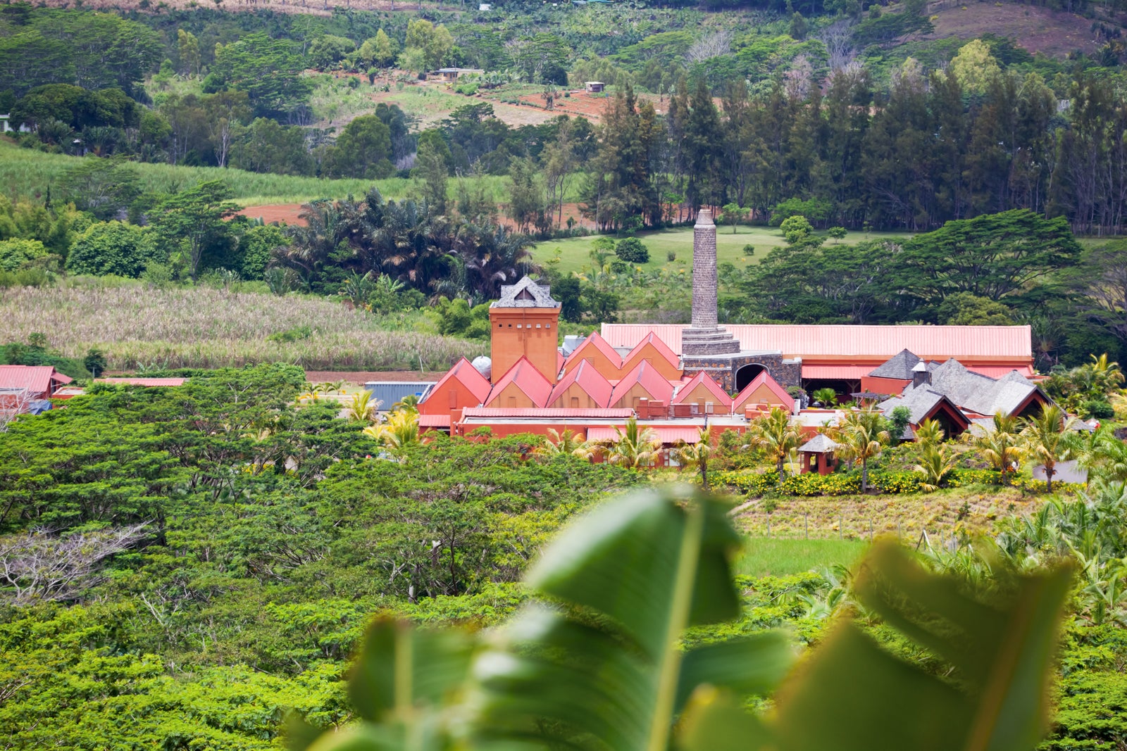 A red-roofed building in the middle of green fields