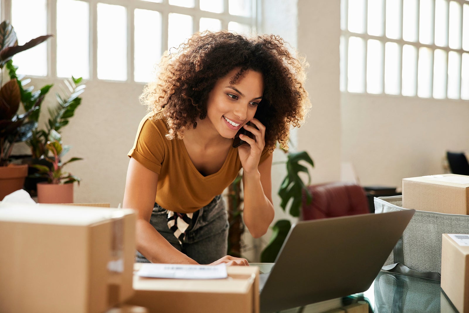 Woman on her phone and laptop in an office