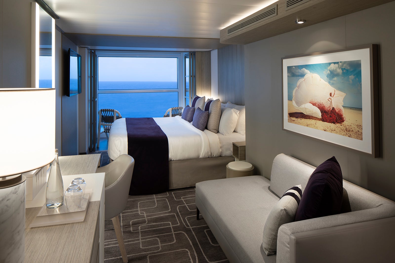 Celebrity Edge AquaClass spa cabin with neutral-colored bed and couch with purple accents