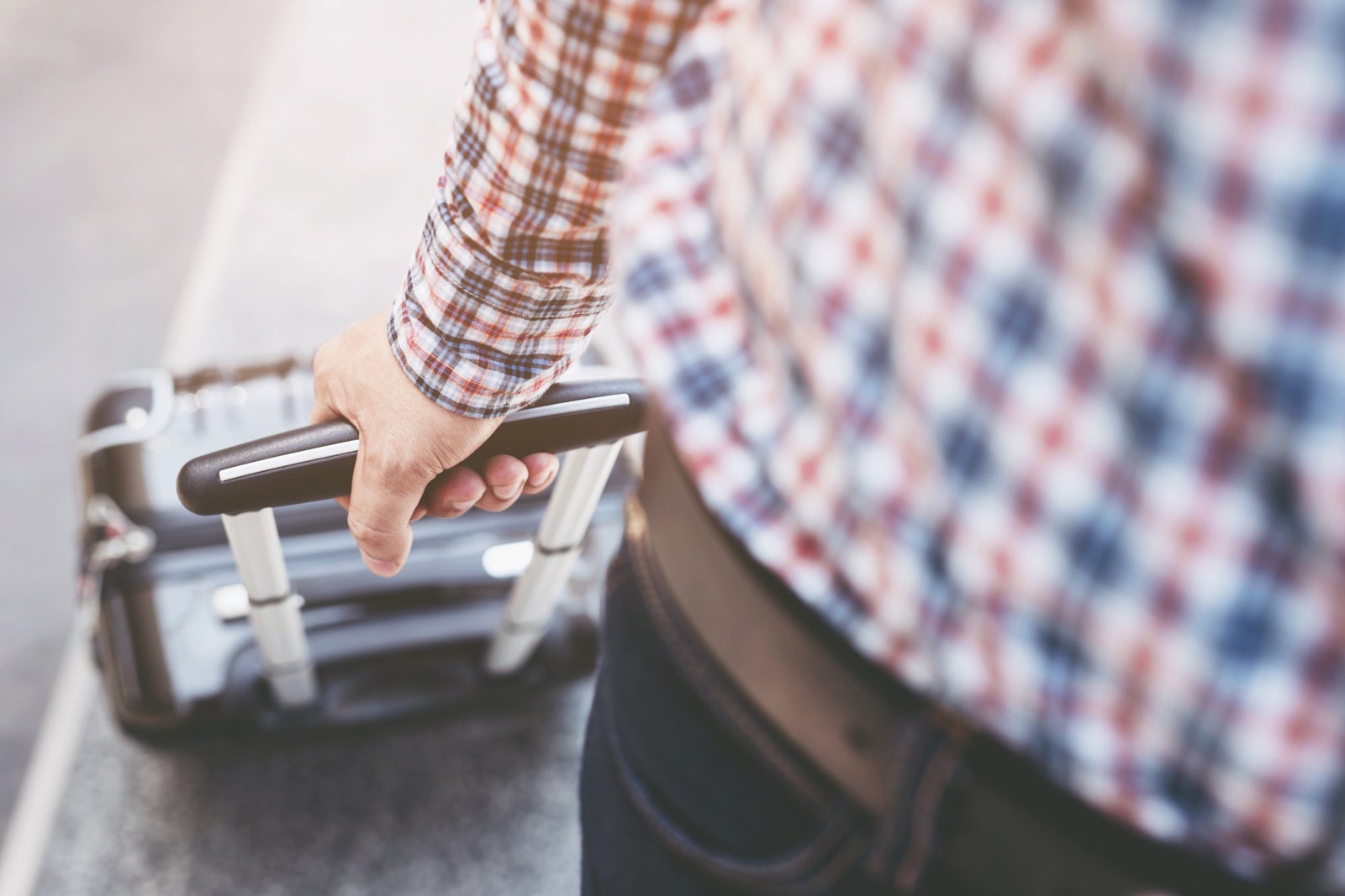 A traveler pulling a rolling suitcase